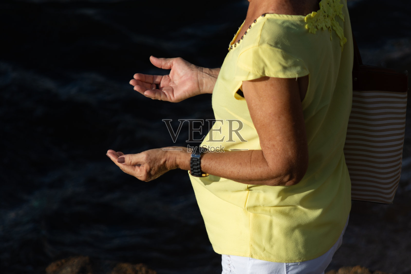 一名蜡烛成员在伊曼贾的海滨祈祷。巴伊亚州萨尔瓦多市。照片摄影图片