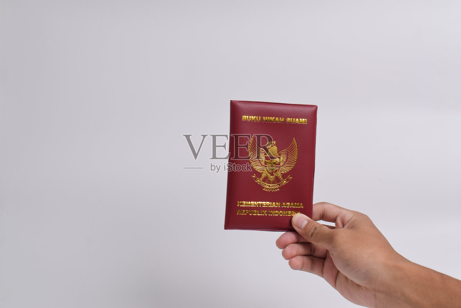 手握丈夫的婚姻书，印度尼西亚共和国宗教部照片摄影图片