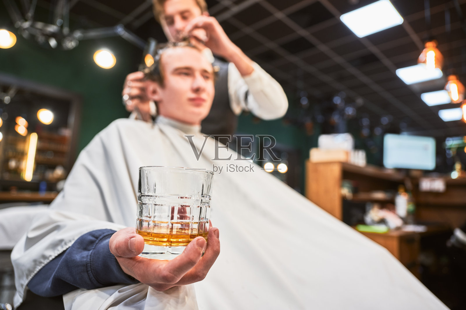 年轻客户拿着一杯威士忌的特写照片。照片摄影图片
