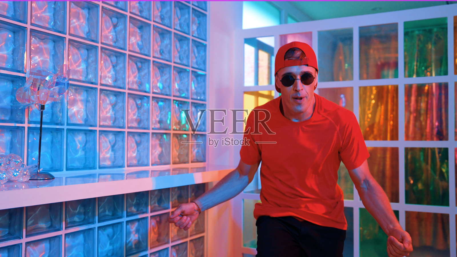 有趣的霹雳舞演员一边看镜头一边移动自由式舞步。盛宴。照片摄影图片