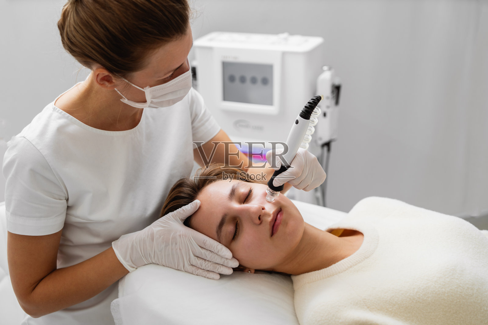 美容师在美容院进行水力打桩。皮肤护理。照片摄影图片