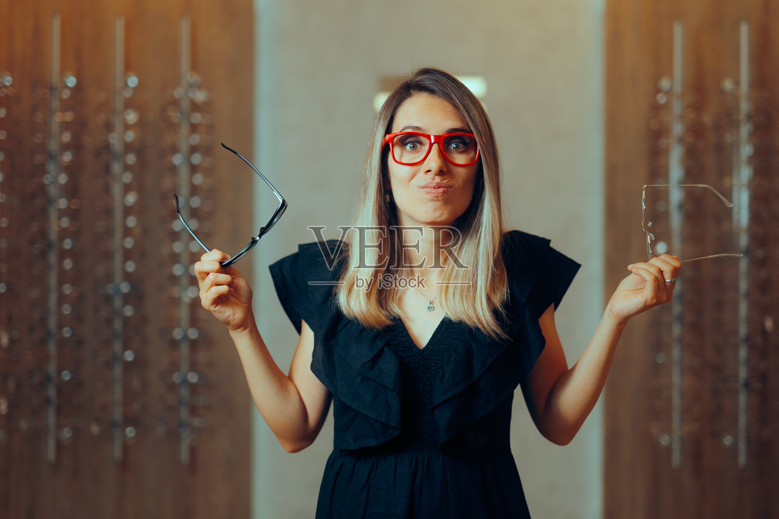 犹豫不决的女人选择新的眼镜框照片摄影图片