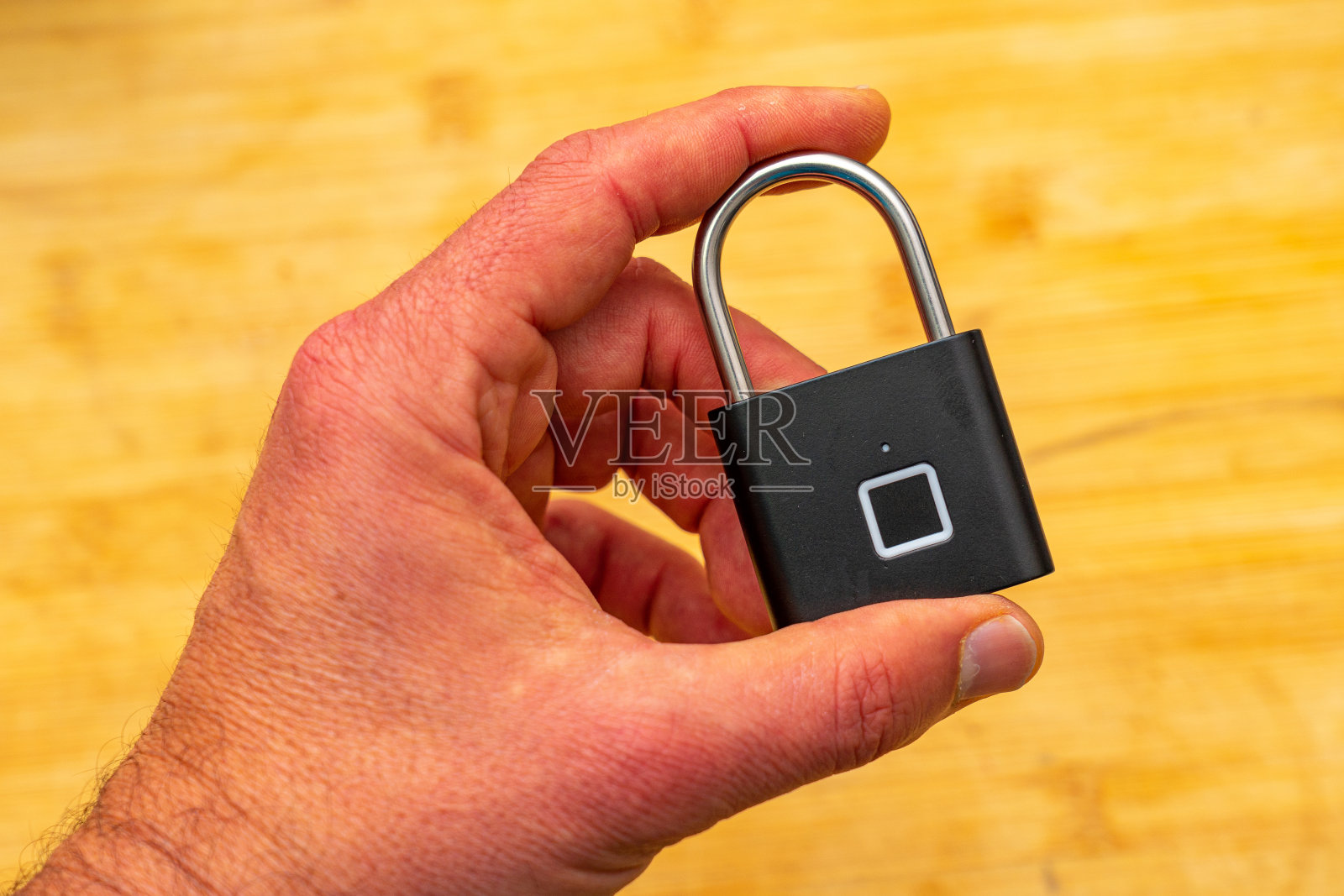 黑色生物识别挂锁，指纹通过方形传感器在手握照片摄影图片