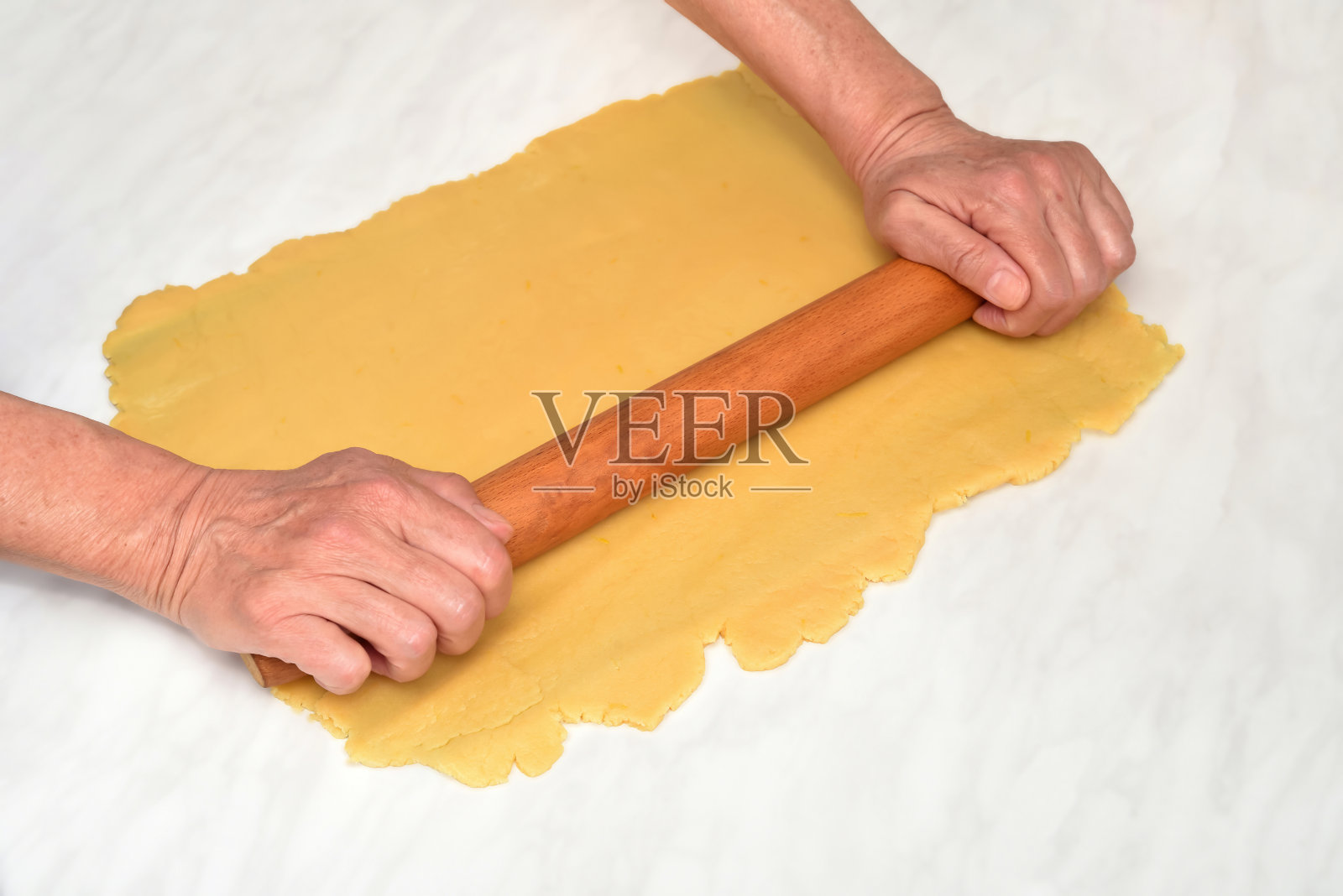 女性用手用木制擀面杖擀面团做馅饼或饼干照片摄影图片