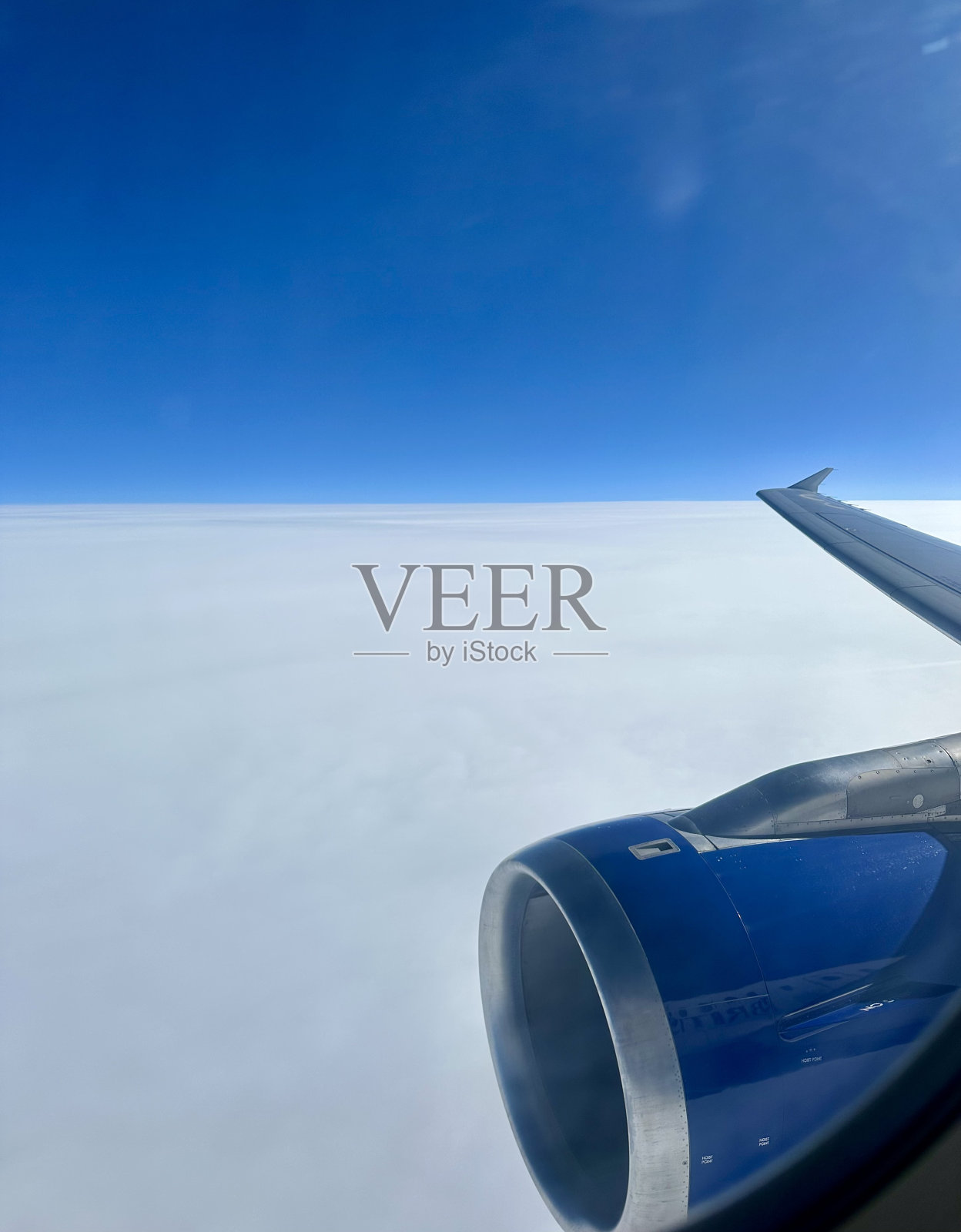 从云层上方的飞机窗口鸟瞰照片摄影图片