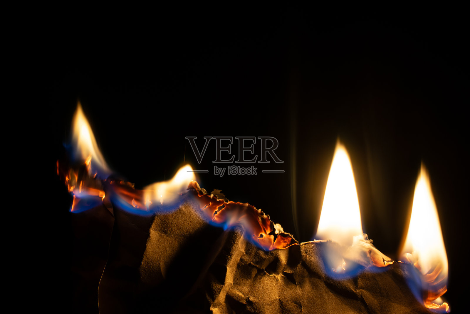 燃烧的纸，在黑色背景上发光的纸边照片摄影图片