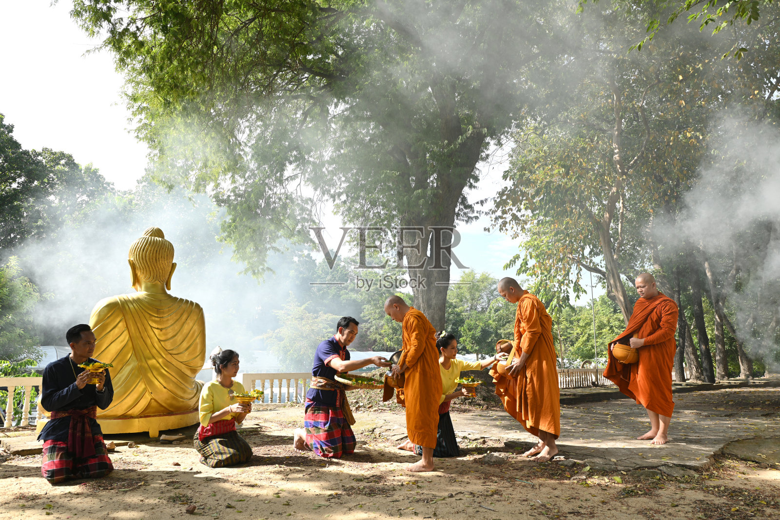 在泰国新武里省的一座寺庙里，人们在早晨给和尚施舍。照片摄影图片
