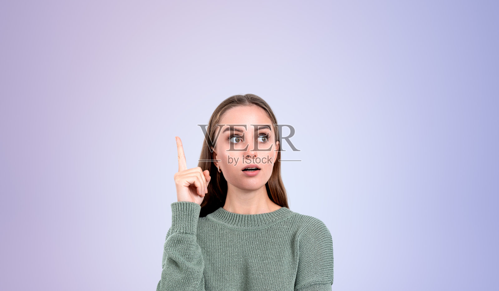 吃惊的年轻女子指着上面照片摄影图片