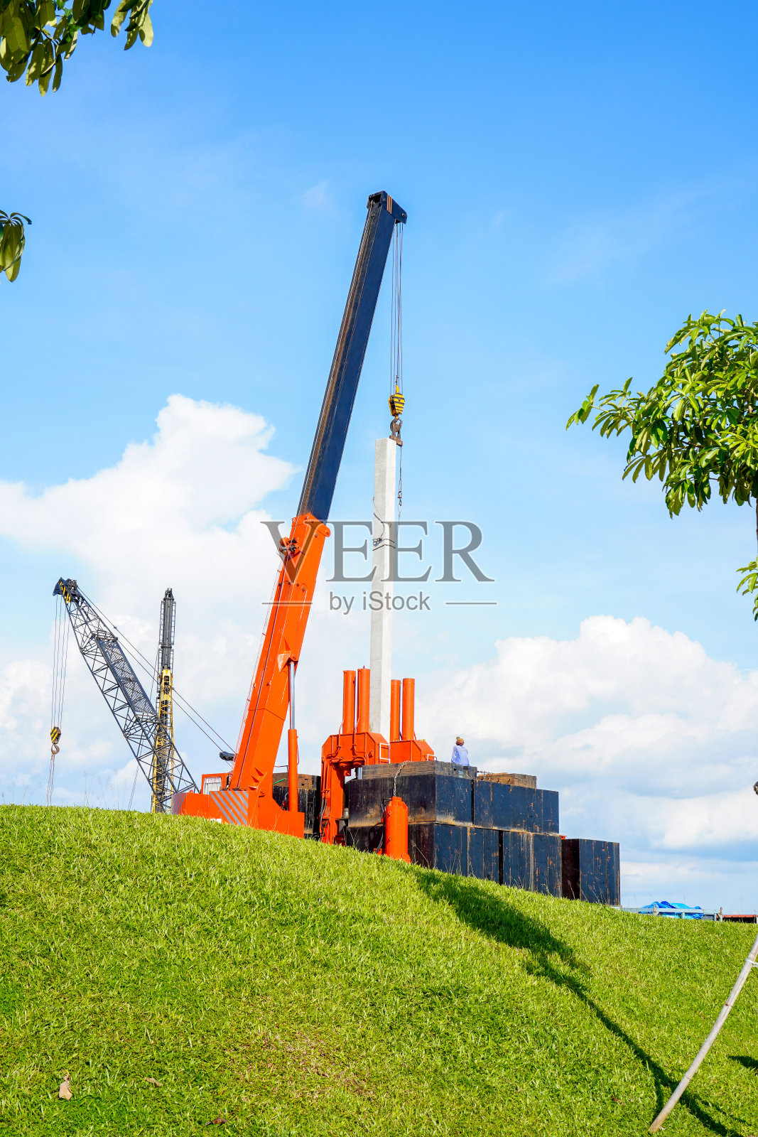 一名工人监督起重机吊起重物照片摄影图片