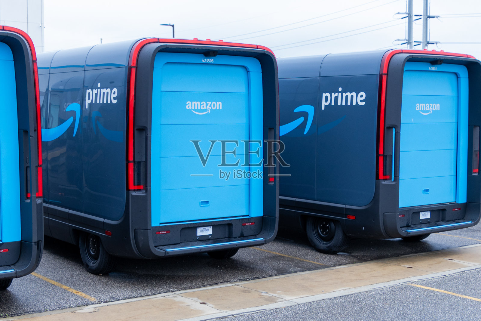 亚马逊Prime配送车在配送中心排成一排，展示了每天送货的准备情况。照片摄影图片