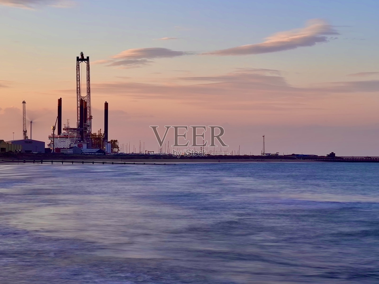 长时间曝光北海与布莱斯港工业在日落的背景照片摄影图片