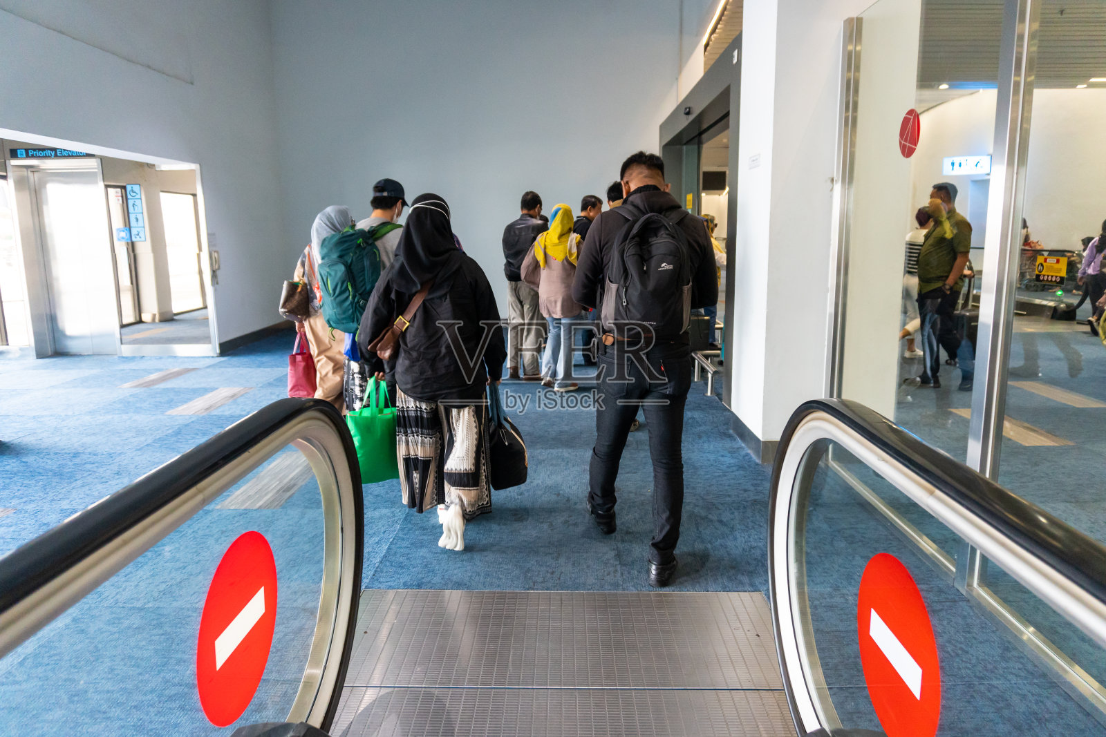 在苏加诺·哈达机场3号航站楼乘坐扶梯下楼的乘客照片摄影图片