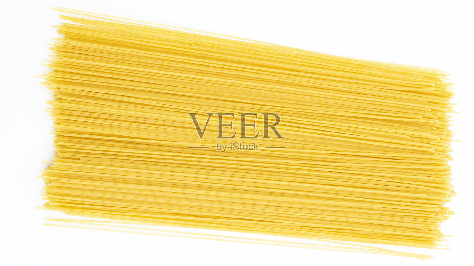 一堆生的长长的意大利面孤立在白色的背景上。照片摄影图片