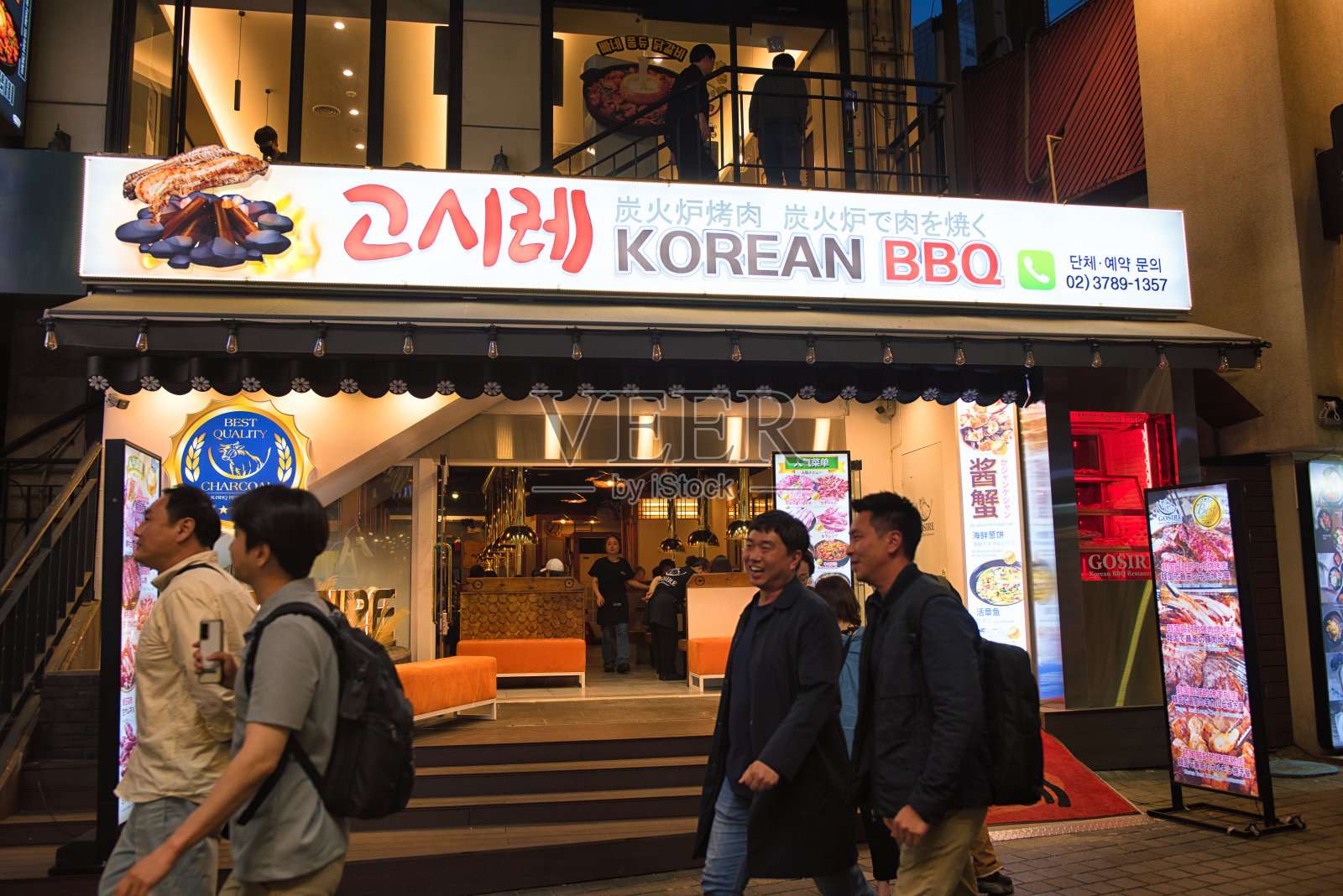 游客们走在明洞购物街的韩国餐厅小巷里照片摄影图片