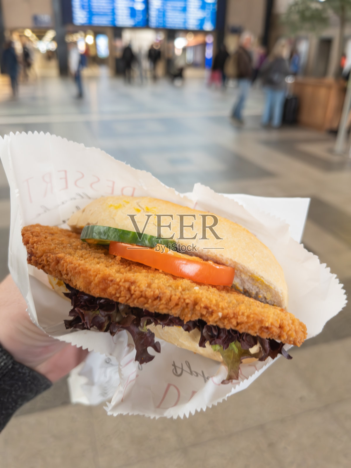 在繁忙的火车站，新鲜美味的鸡肉三明治照片摄影图片