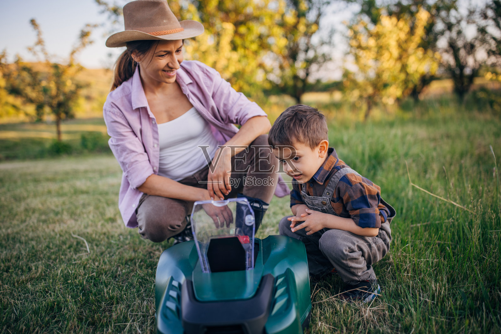 在农场与机器人割草机共度家庭时光照片摄影图片