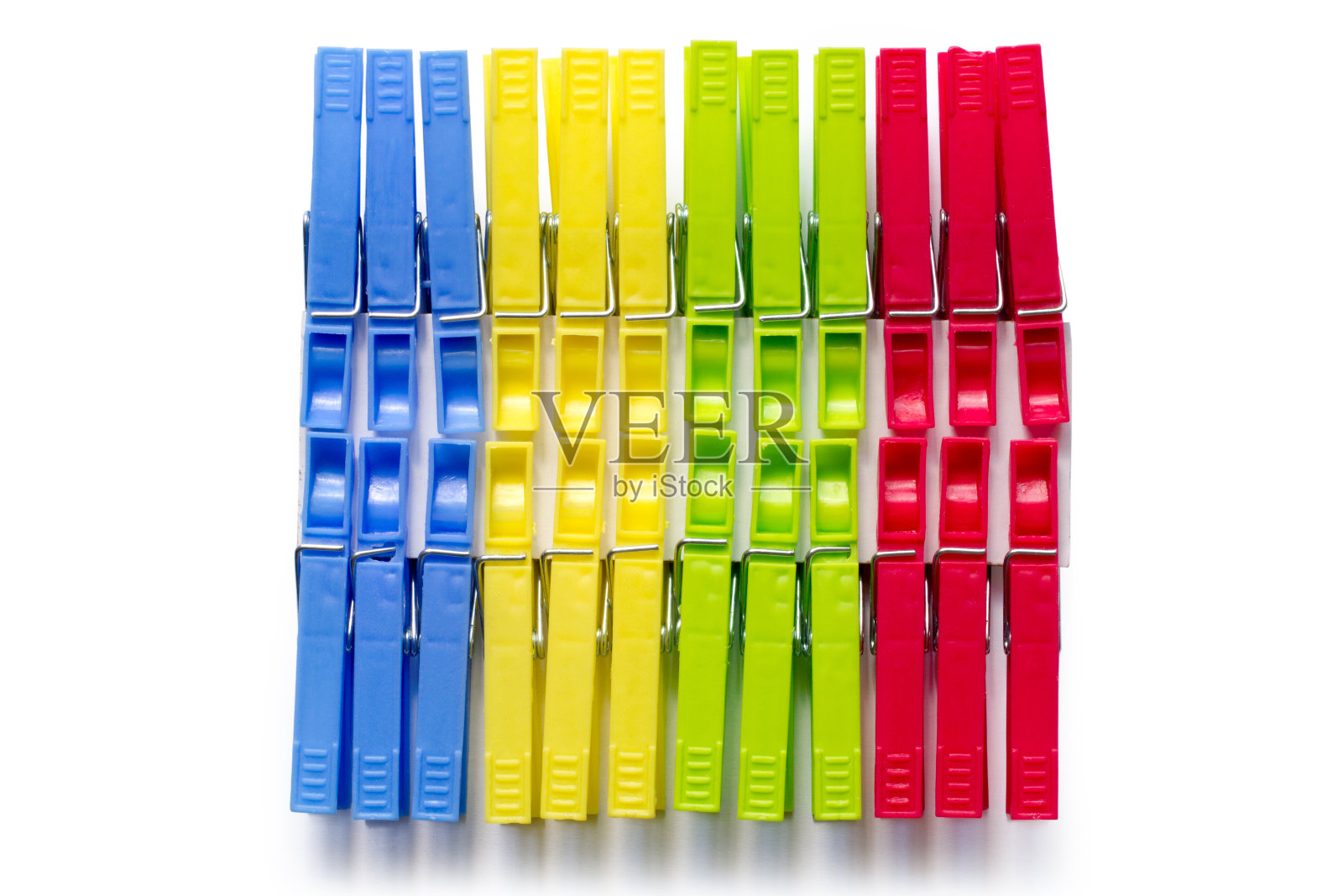 一套白色背景上的彩色衣夹。照片摄影图片