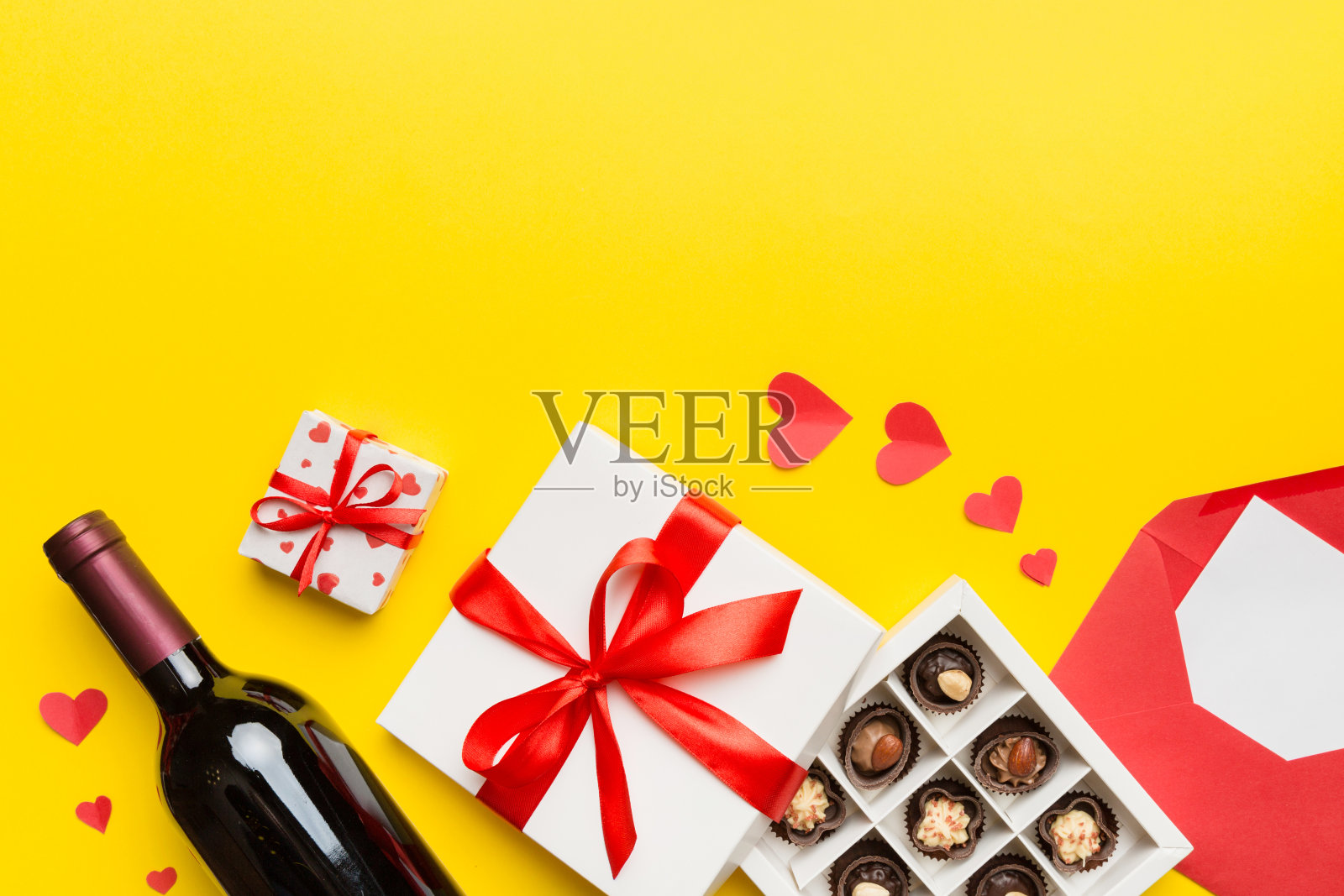 一瓶红酒在彩色背景情人节与礼盒，信封和巧克力。心形与巧克力礼盒顶部视图与复制空间照片摄影图片