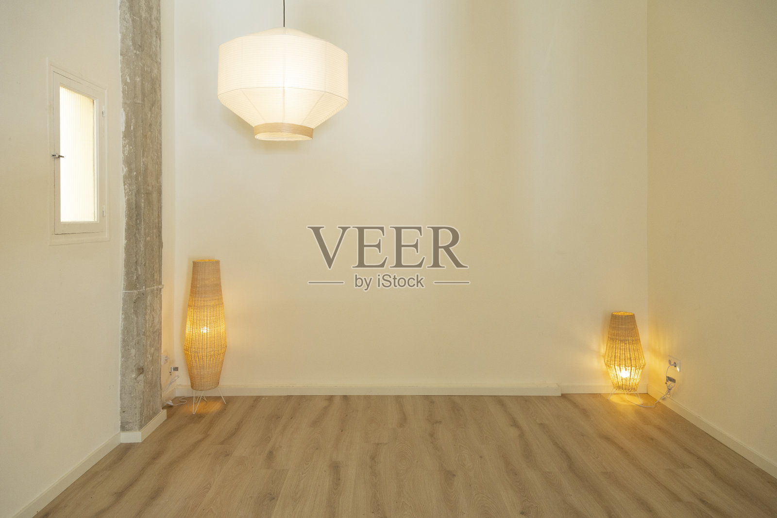 现代感十足的房间，配有大型吊灯和竹制落地灯。照片摄影图片