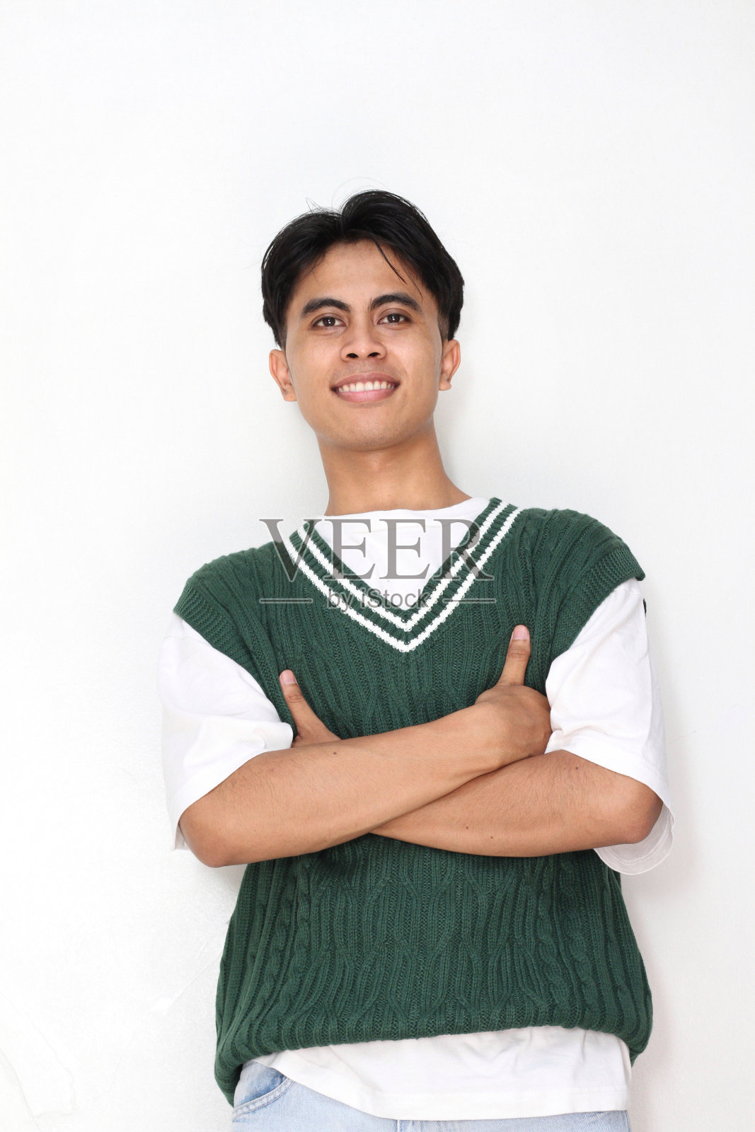 一个中年亚洲男人的肖像，穿着休闲服，双臂交叉，对着镜头微笑照片摄影图片