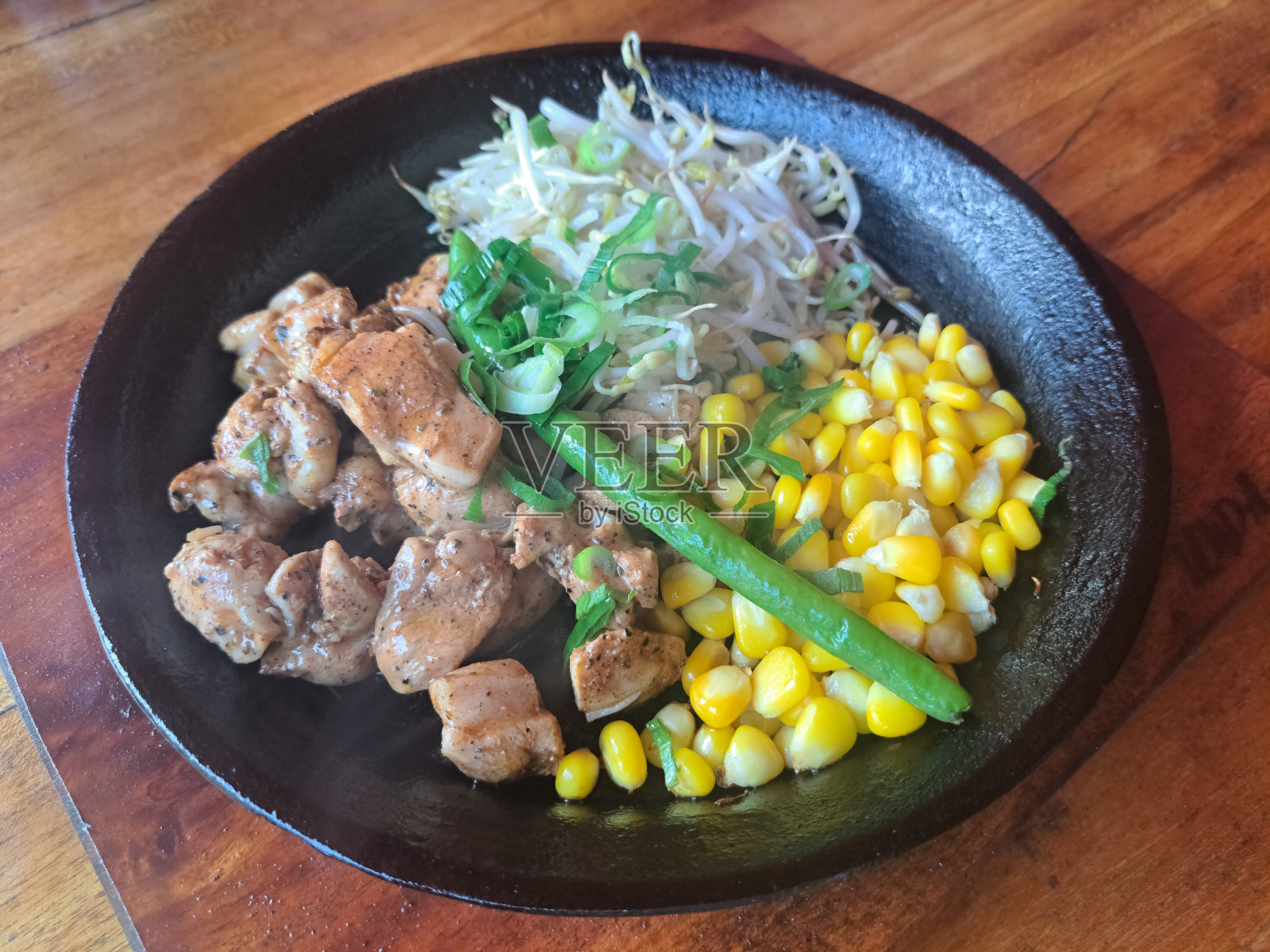 美味的鸡椒牛排。搭配鸡肉，豆芽，长豆，切碎的香葱和玉米种子。食品菜单。照片摄影图片