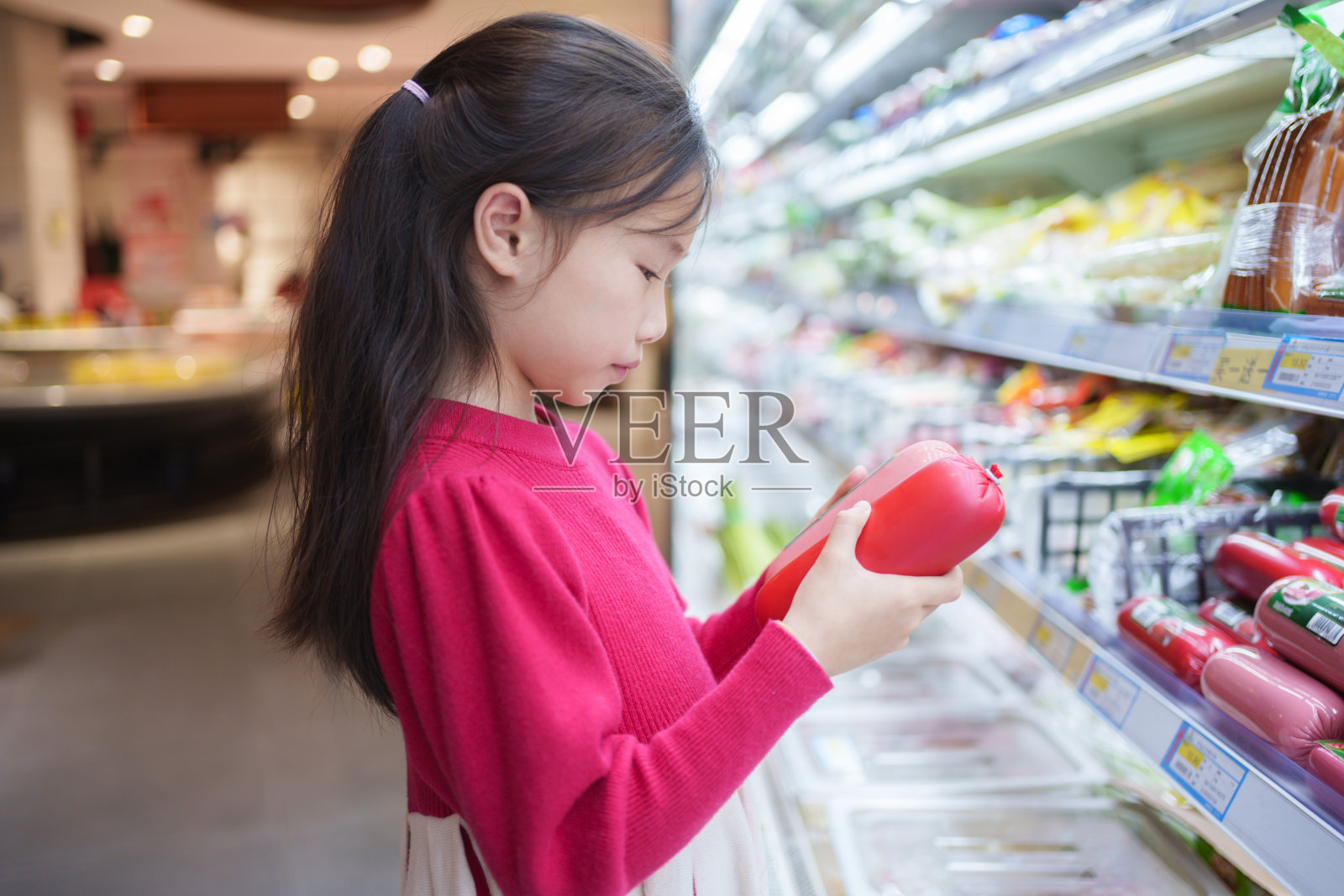 小女孩在买火腿照片摄影图片