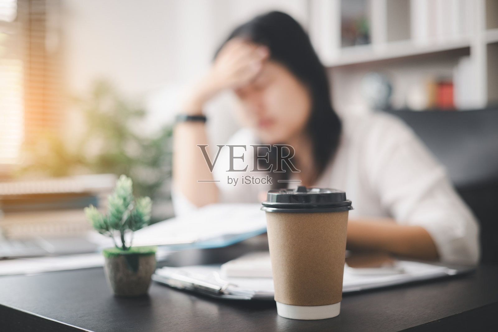 压力山大的女商人，面对工作压力和抑郁的重压，发现自己在办公室里挣扎，感到困倦，被工作的要求压垮了。照片摄影图片