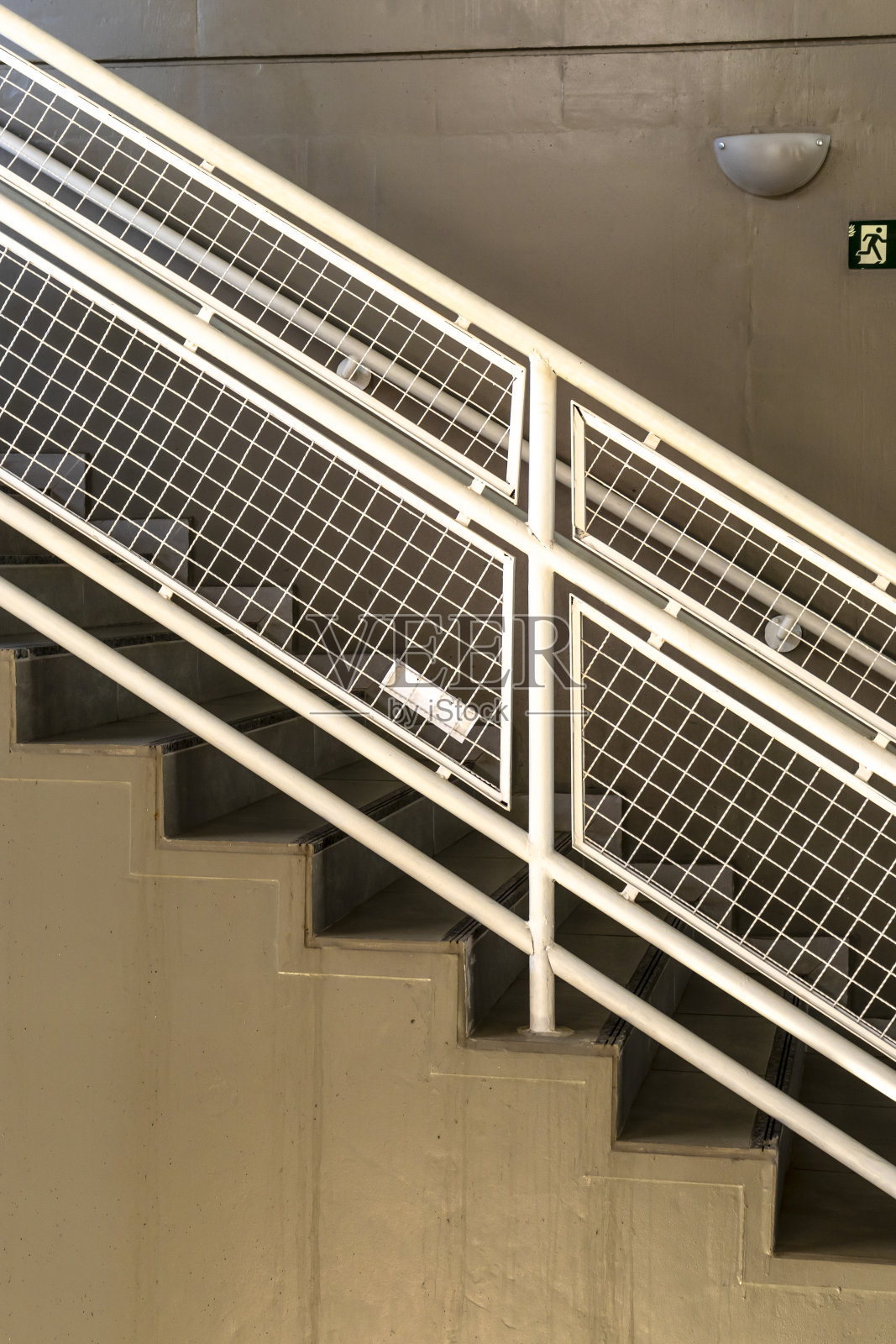 现代商业建筑内带有白色金属扶手的混凝土楼梯照片摄影图片