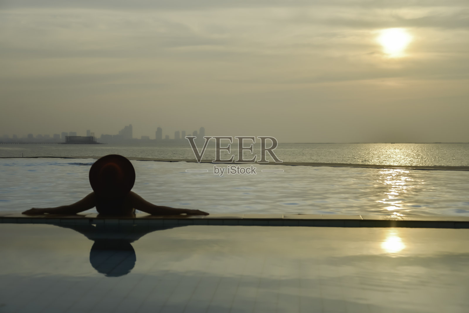 年轻的亚洲女子微笑着在室外游泳池周围放松休闲照片摄影图片