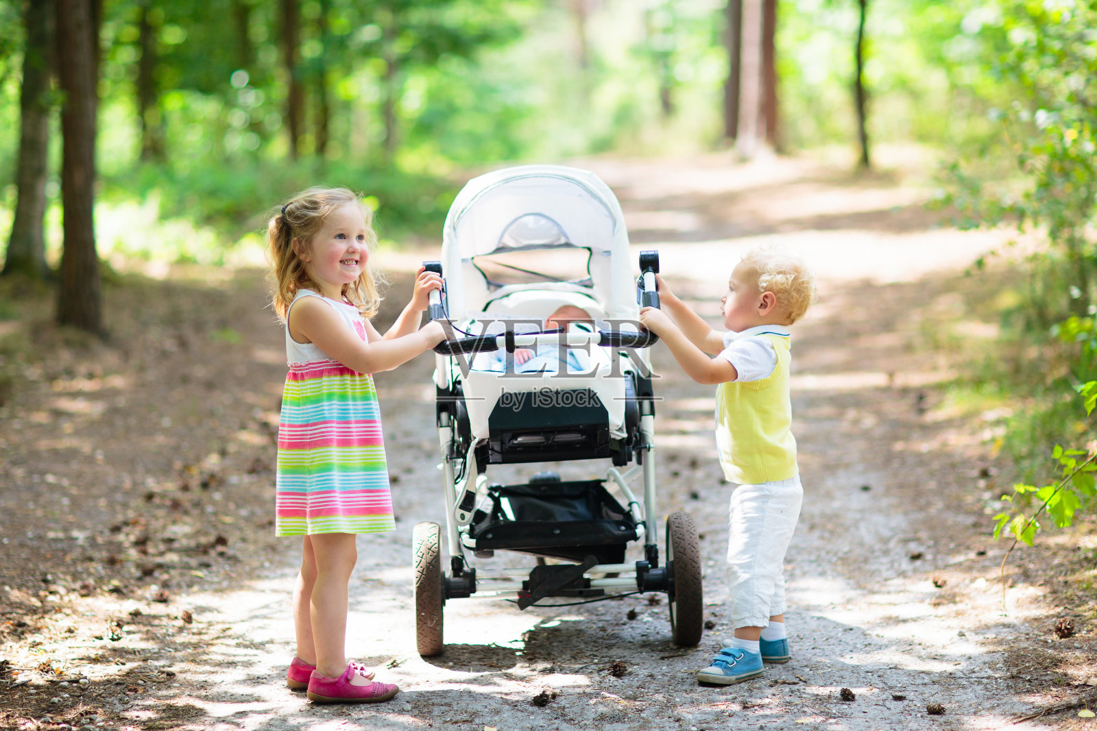 孩子们推着婴儿车和刚出生的婴儿照片摄影图片
