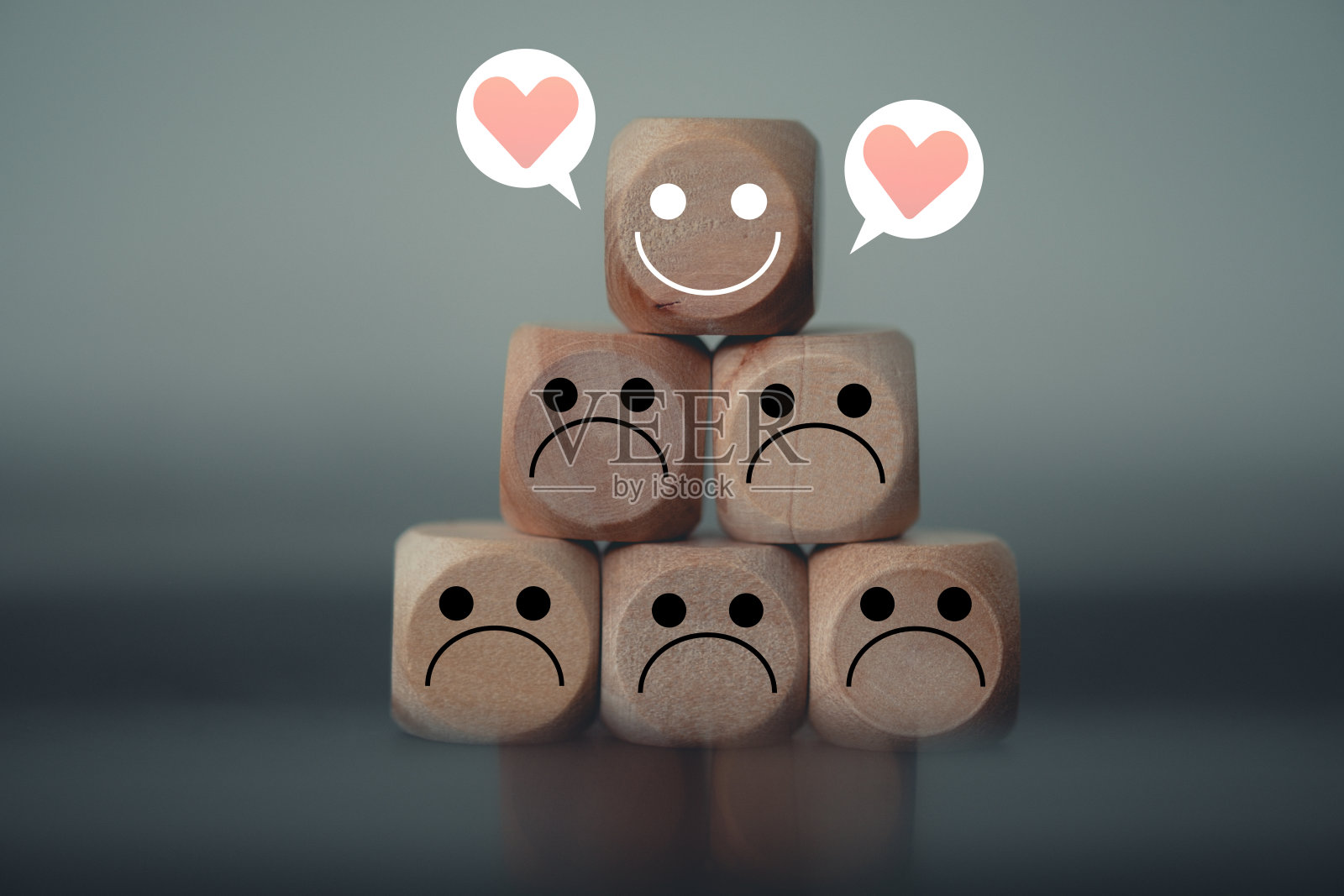 快乐的脸与心的图标在许多悲伤的情绪在木块。消极团队中的快乐领导者。照片摄影图片