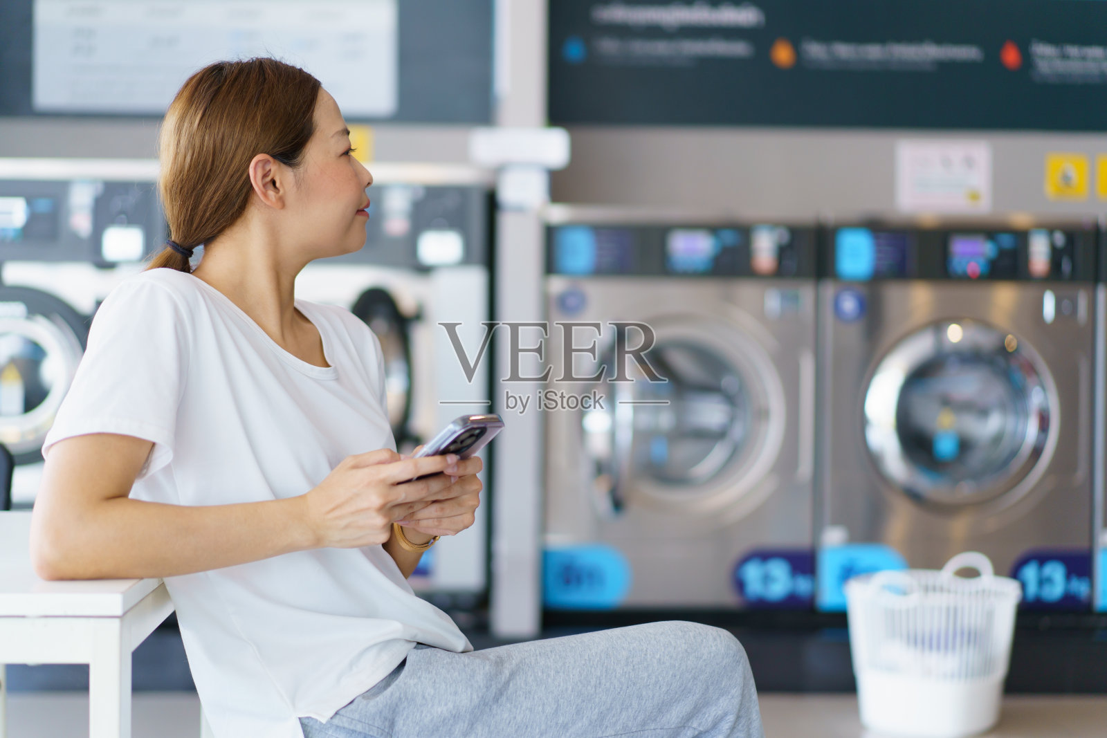 一名妇女在洗衣亭卖主洗衣服。照片摄影图片