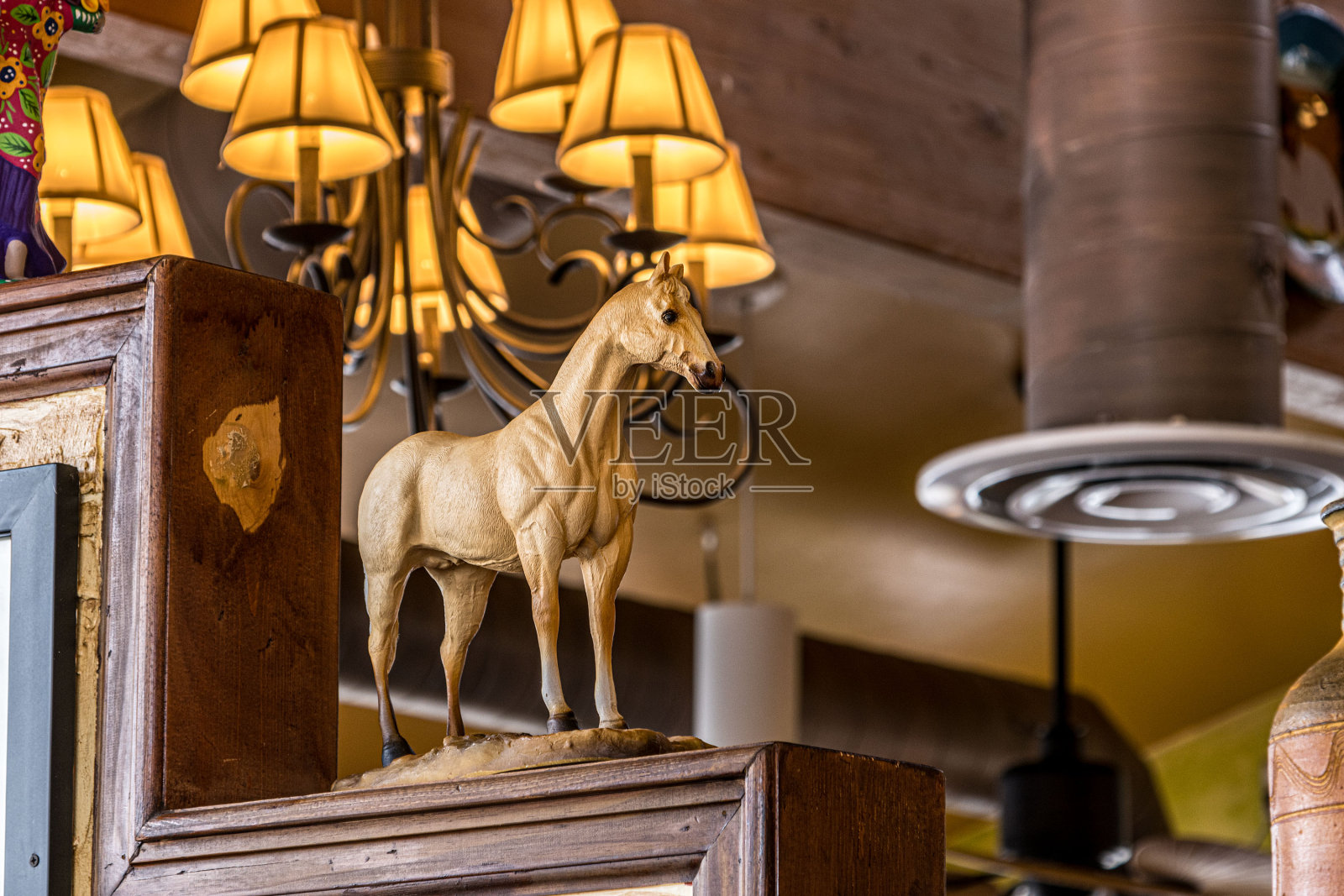 餐厅或办公室内的装饰性和装饰性黄色陶瓷马，由背景灯发出的黄色灯光照亮照片摄影图片