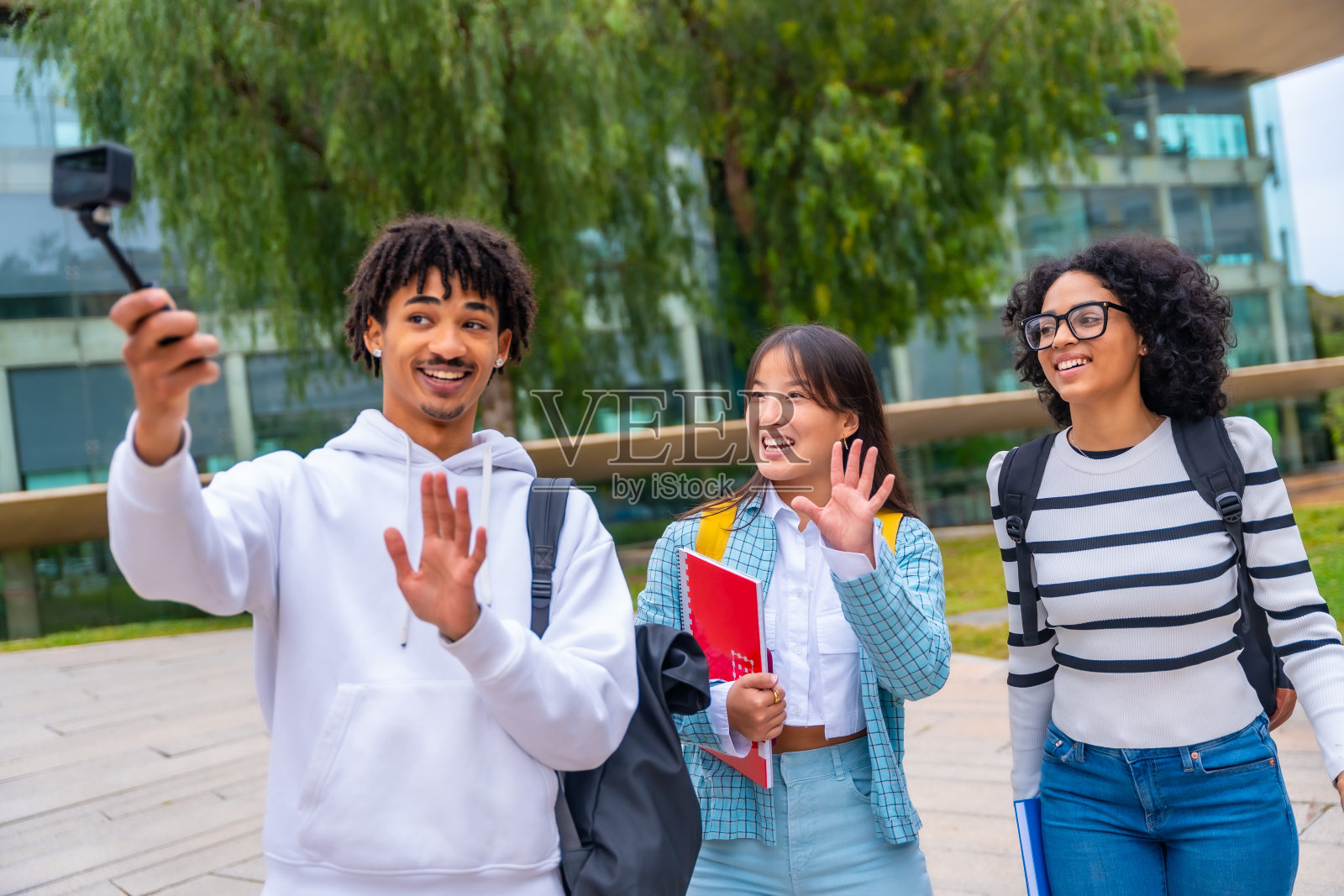 学生们在大学学院外视频通话时挥手照片摄影图片