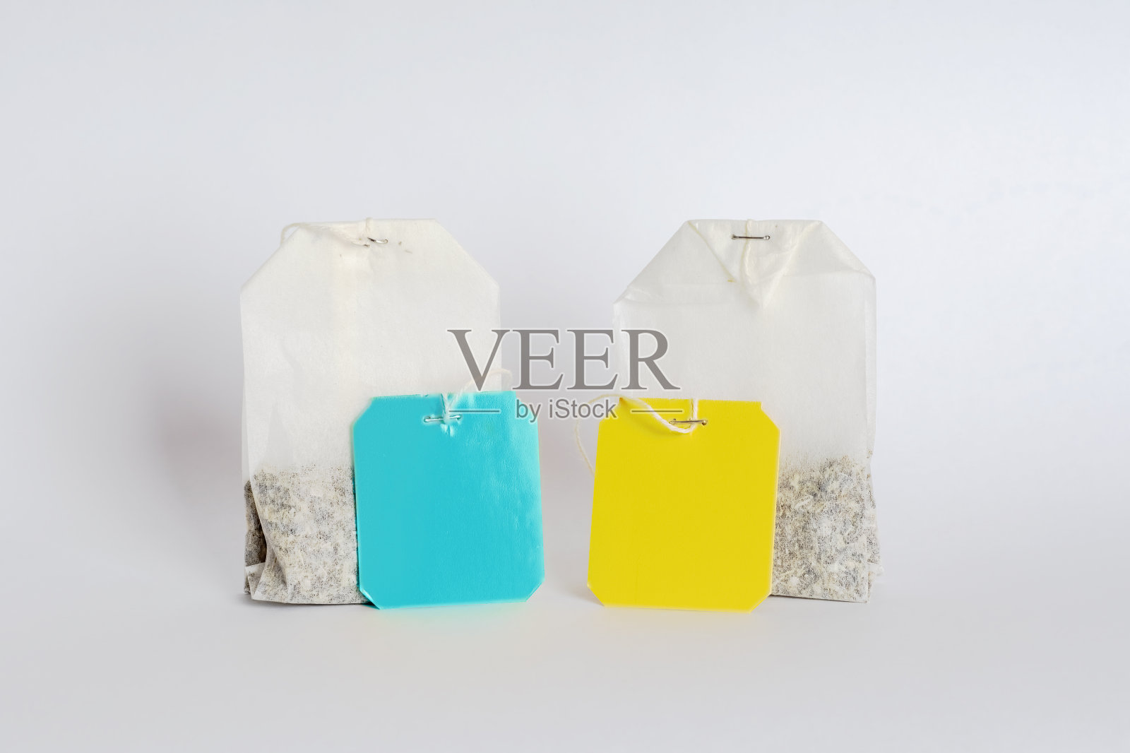 两个茶包，白色背景上有不同颜色的空标签。以热软饮料为主题的空白标签模板。照片摄影图片