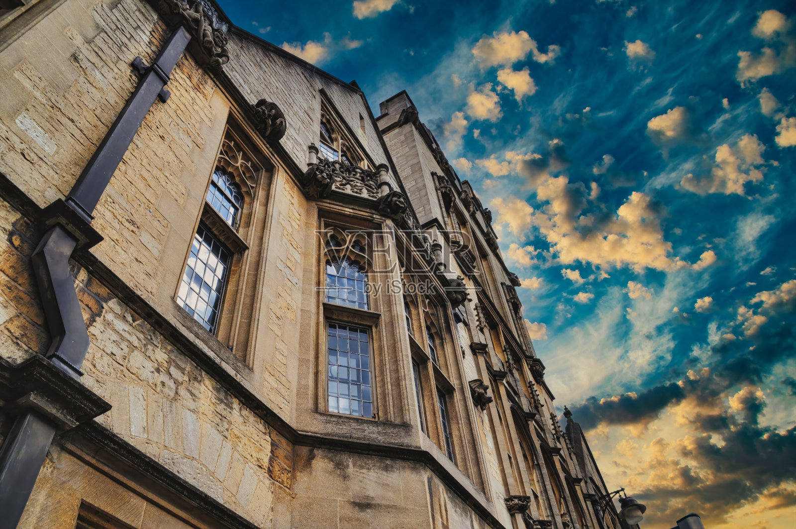 一个古老的石头建筑的正面的底部视图与戏剧性的天空。照片摄影图片