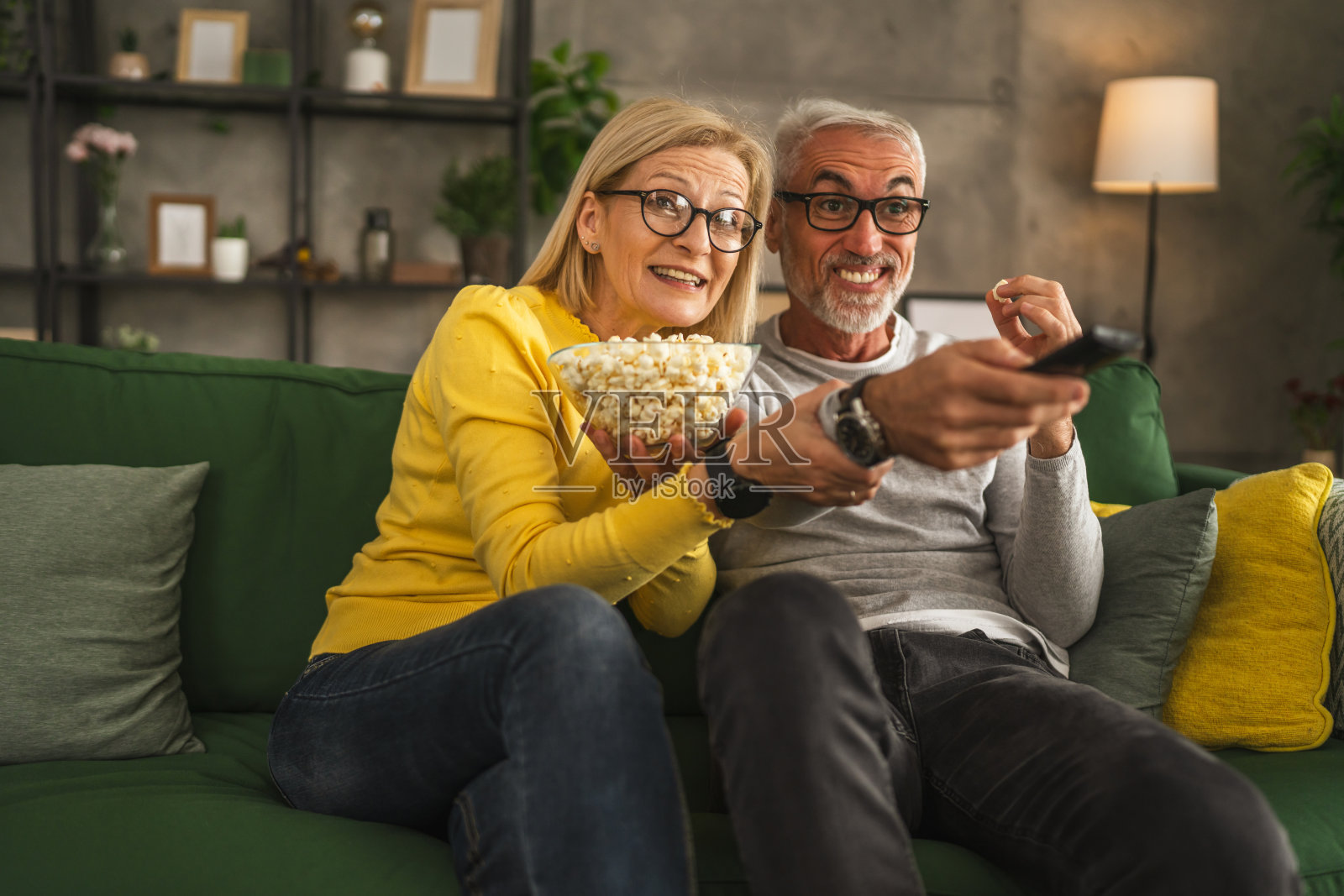 成熟的老年夫妇夫妇看电影，吃爆米花照片摄影图片
