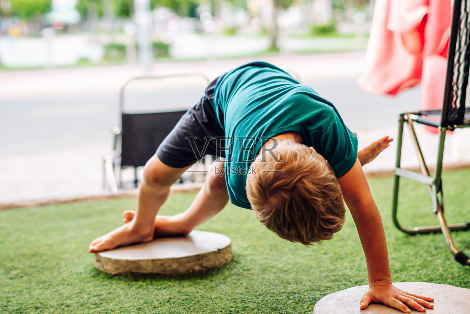 男孩的杂技动作，站在手脚宽阔的台阶上，在任何地方都可以自由自在地做自己照片摄影图片