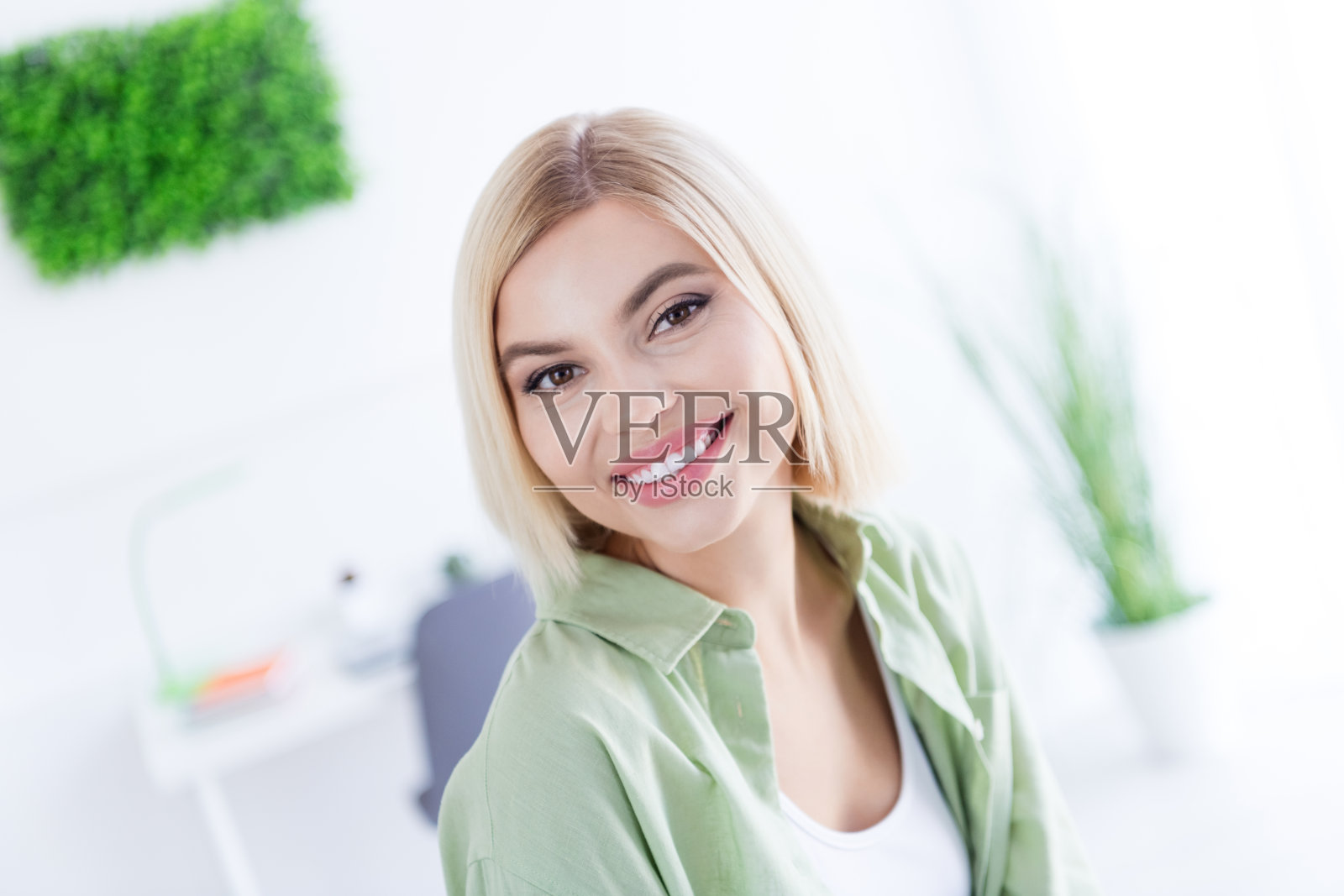 年轻的金发鲍勃发型模特的肖像照片微笑着高兴可爱的女人放松地呆在家里在她的阁楼风格室内家庭背景照片摄影图片