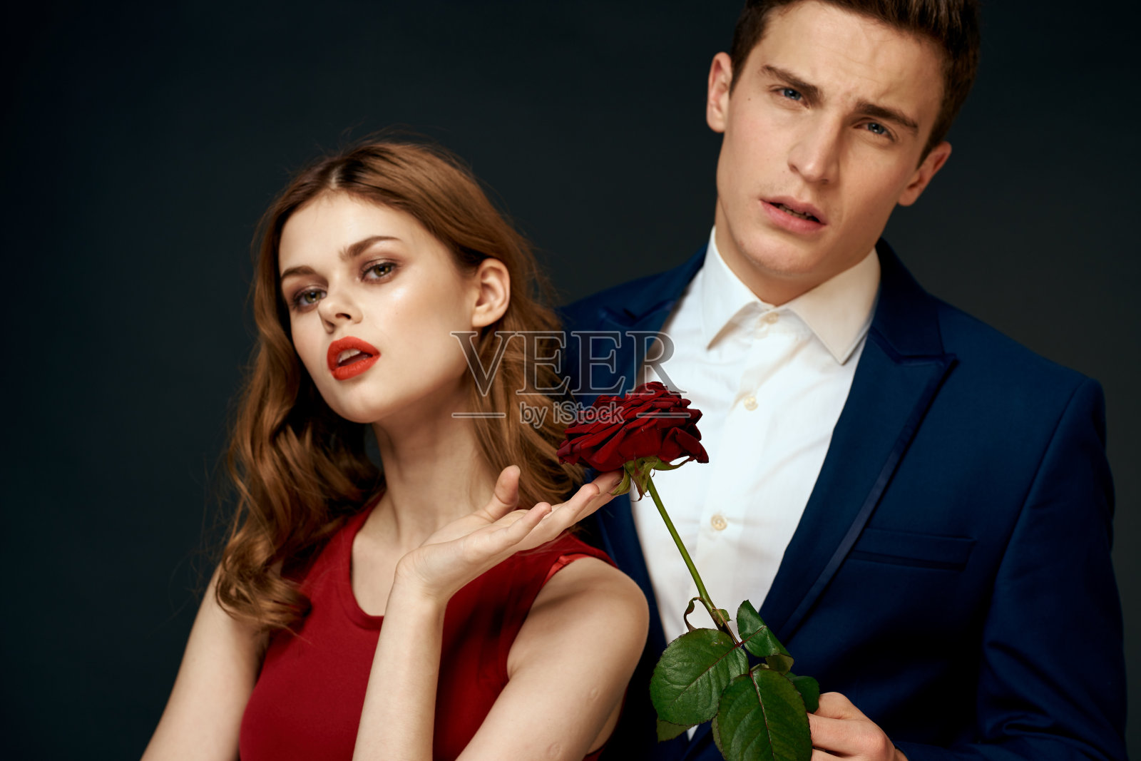 年轻夫妇拥抱魅力红玫瑰关系黑色背景照片摄影图片