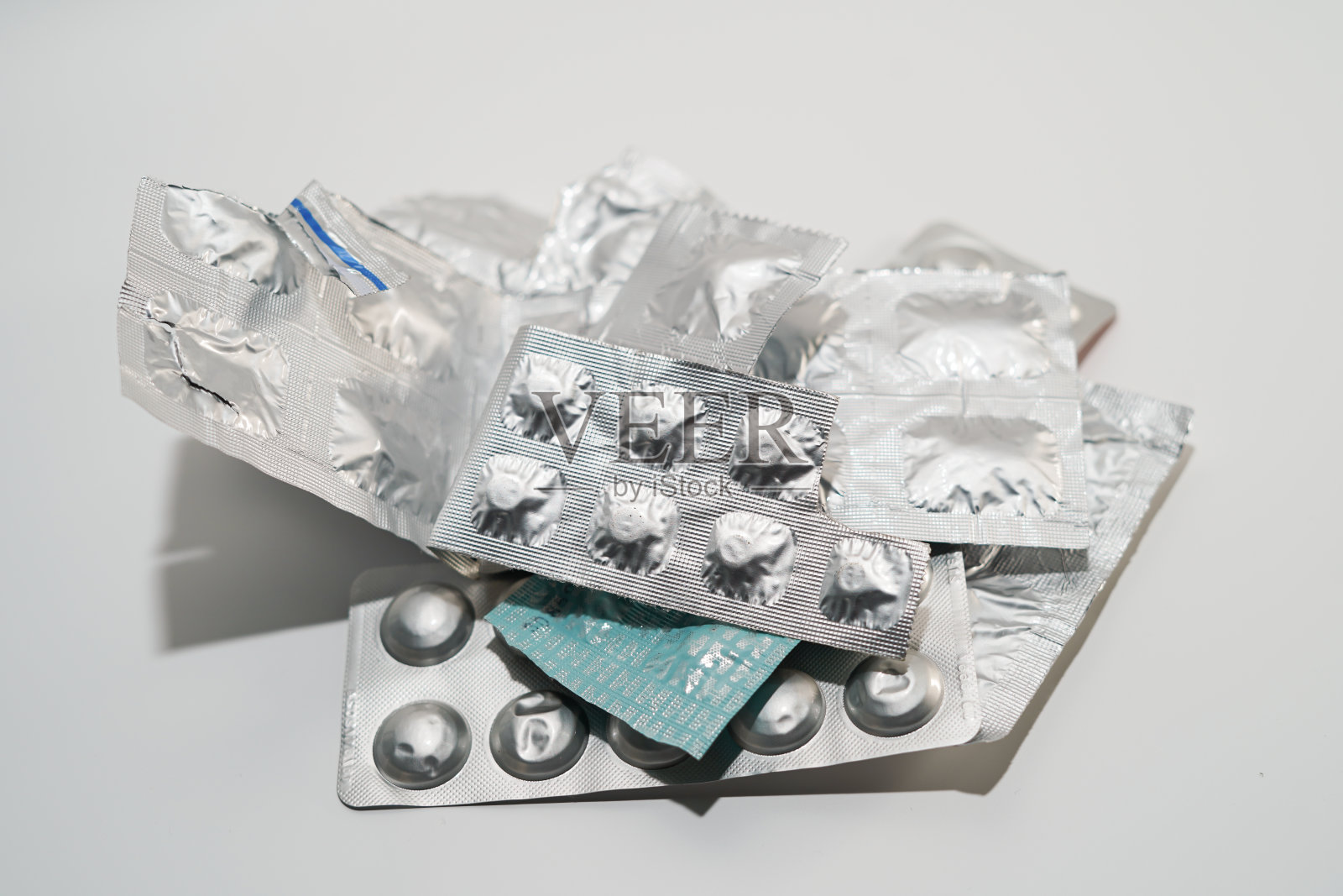 堆不同的药物组在吸塑条形包装上的白色背景。孤立的照片摄影图片