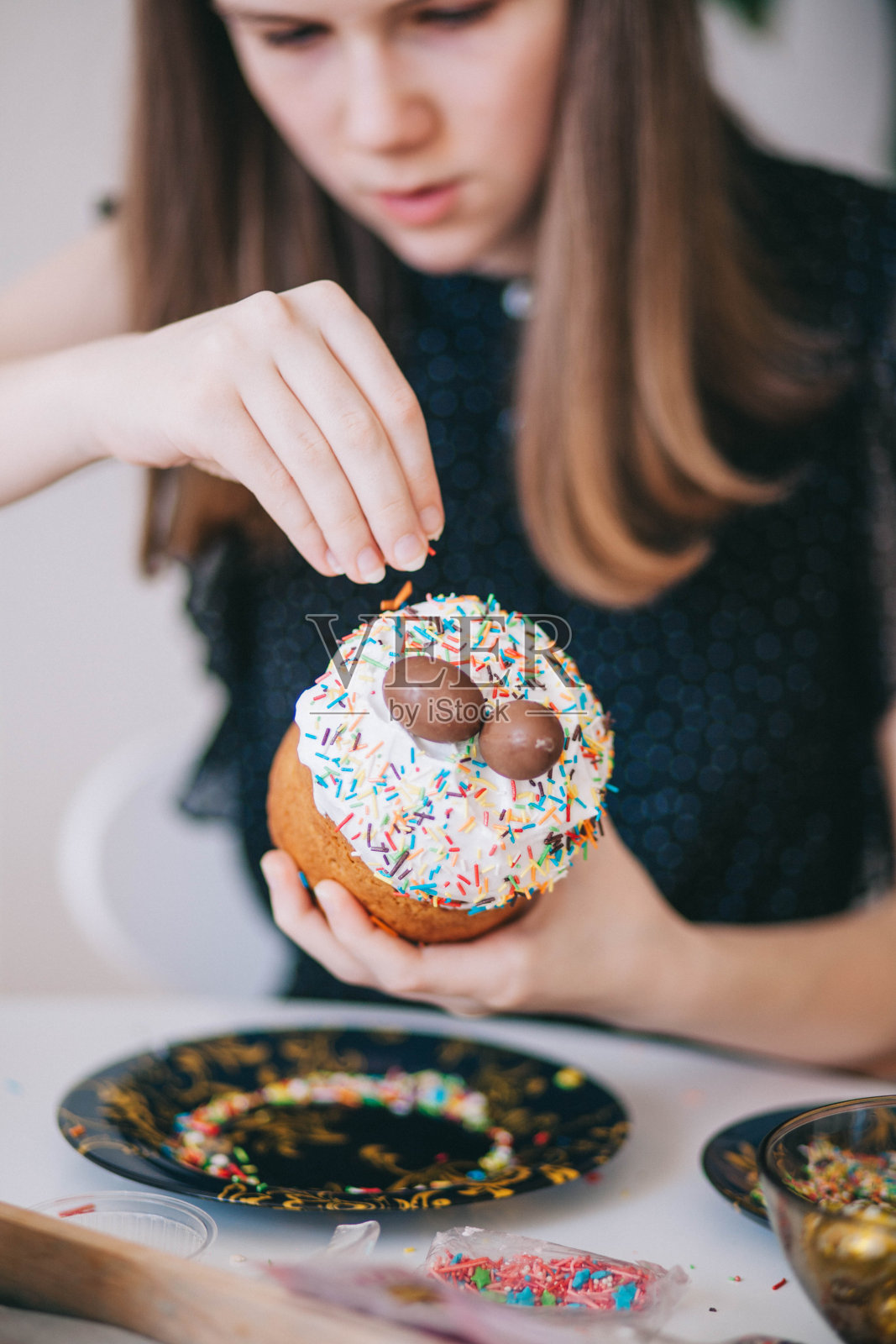 一个女孩为复活节装饰传统的乌克兰糕点。照片摄影图片