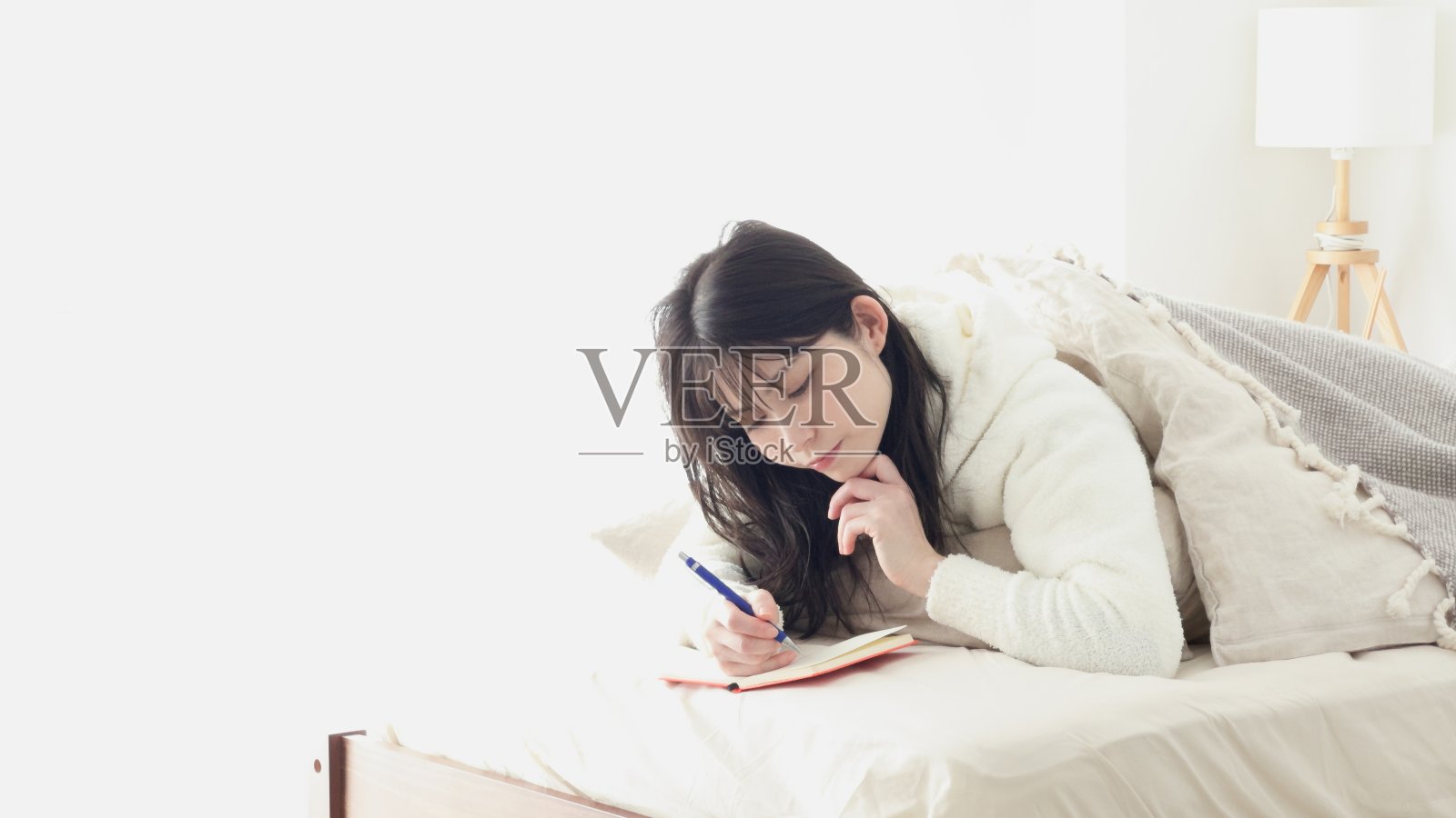 亚洲女人睡觉时记笔记照片摄影图片