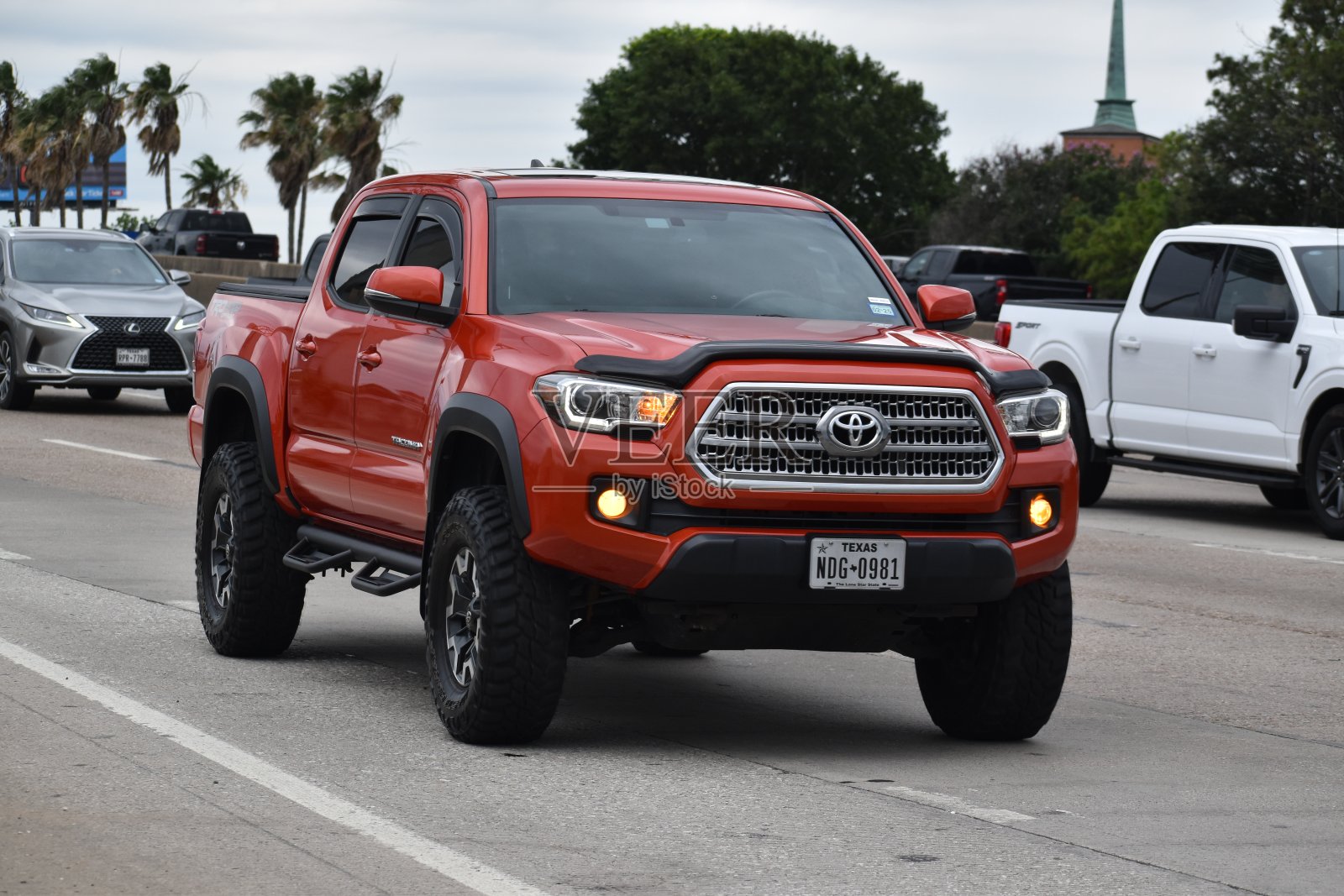 一辆红色的丰田塔科马4x4皮卡在交通不拥挤的高速公路上行驶照片摄影图片