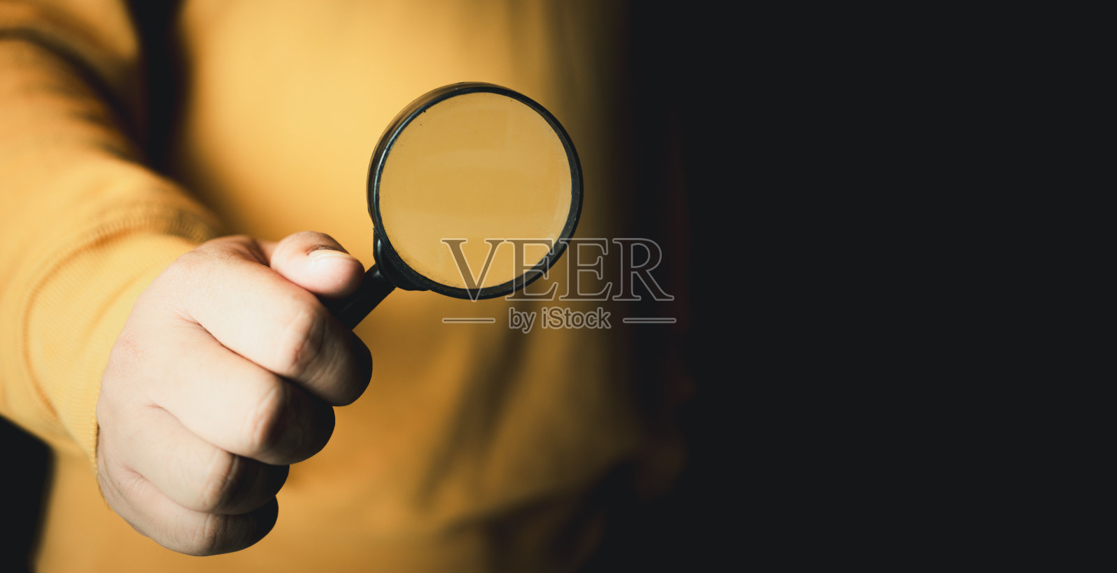 一个人站着，拿着放大镜搜索信息。发现和研究的概念。照片摄影图片