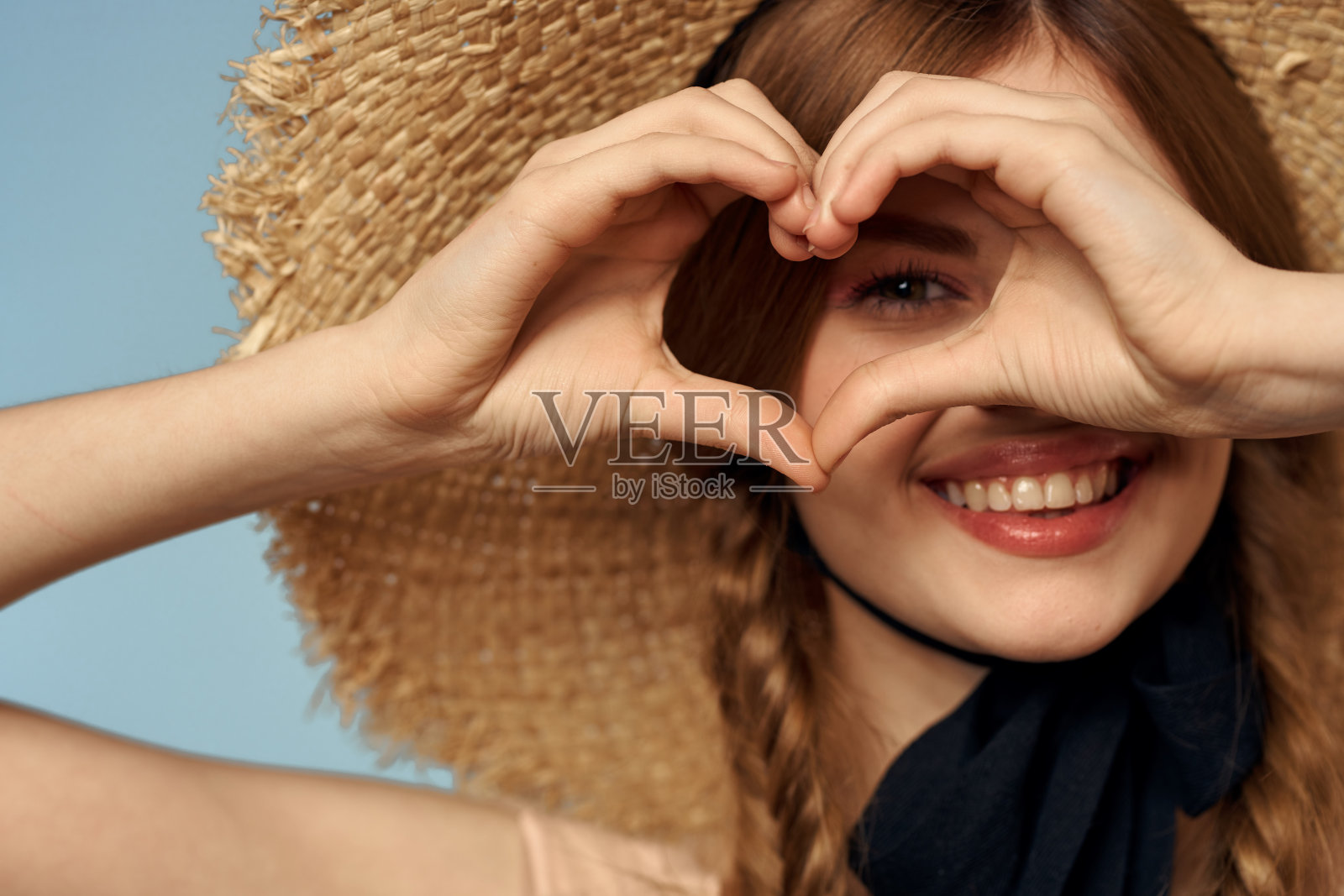 女孩在草帽肖像特写辫子有趣的红头发蓝色背景照片摄影图片