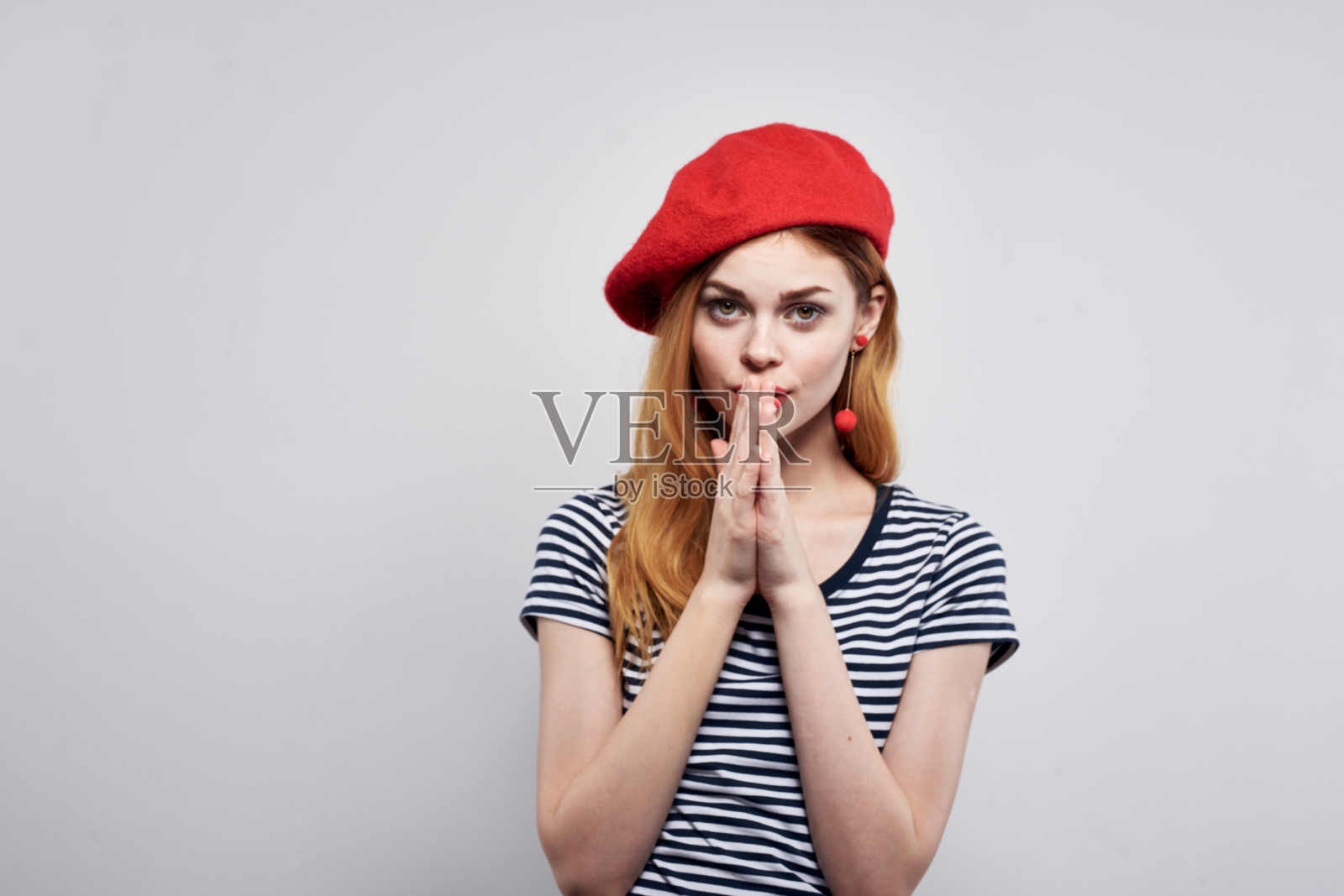 漂亮的女人穿着条纹t恤，红唇手势，双手孤立的背景照片摄影图片