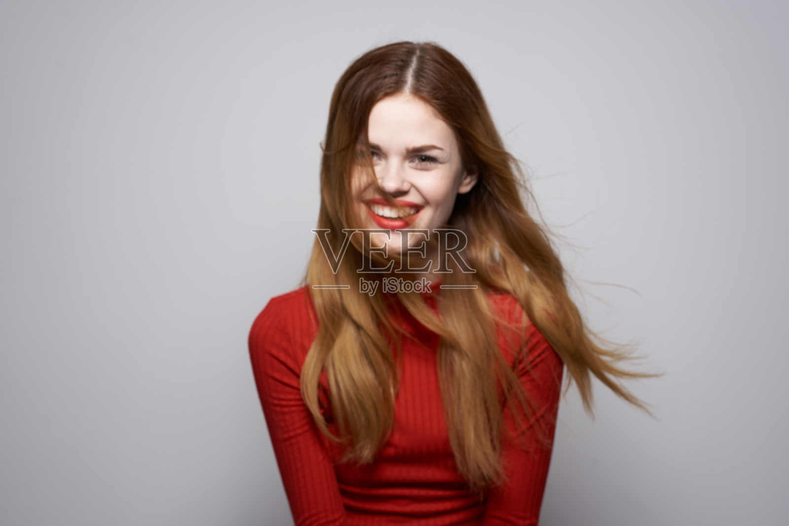 美丽的女人在红色的裙子摆姿势豪华的手势工作室照片摄影图片