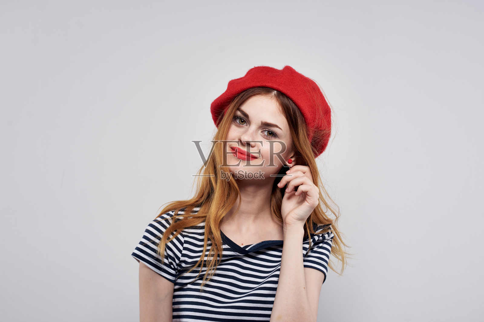 美丽的女人摆出时尚迷人的样子，红色耳环，珠宝，浅色背景照片摄影图片