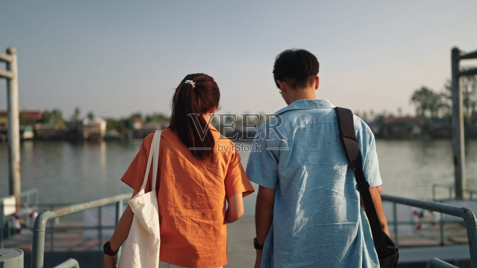 青少年在河边游玩。照片摄影图片